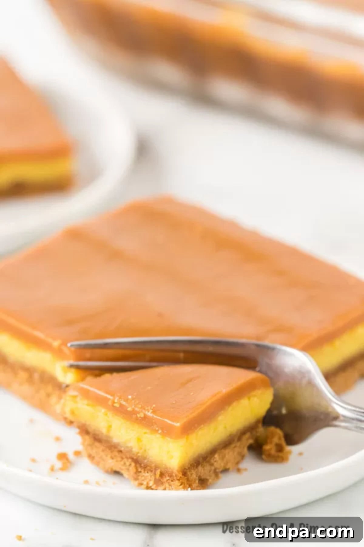 Cheesecake Bar cut and on a plate with a fork. 