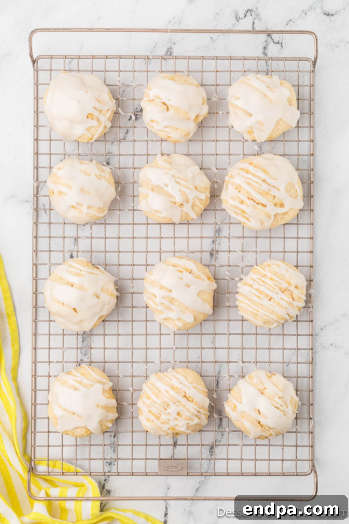 Cooled pineapple cookies on a wire rack, freshly topped with the pineapple glaze, allowing it to set before serving.