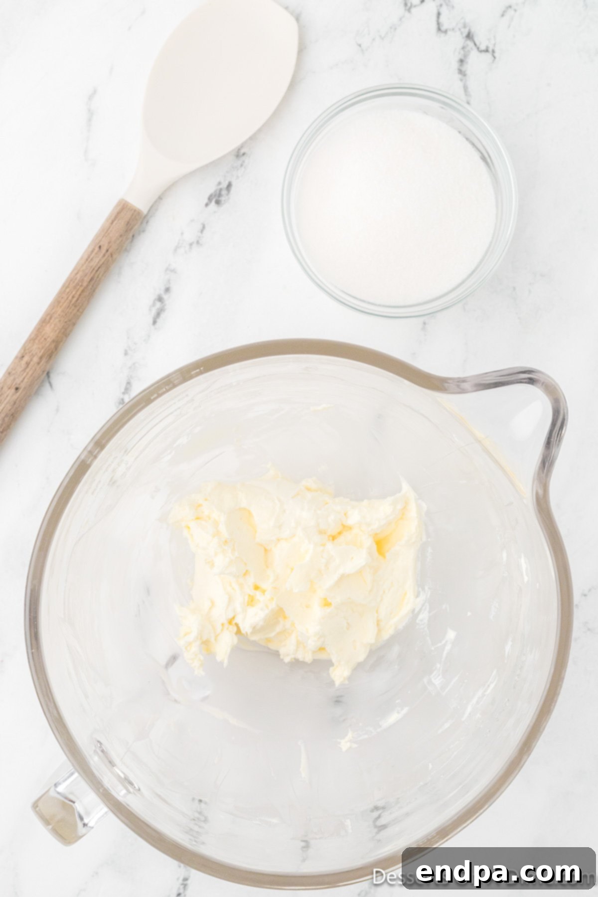 Softened butter and cream cheese are creamed together in a stand mixer until light, airy, and fluffy.