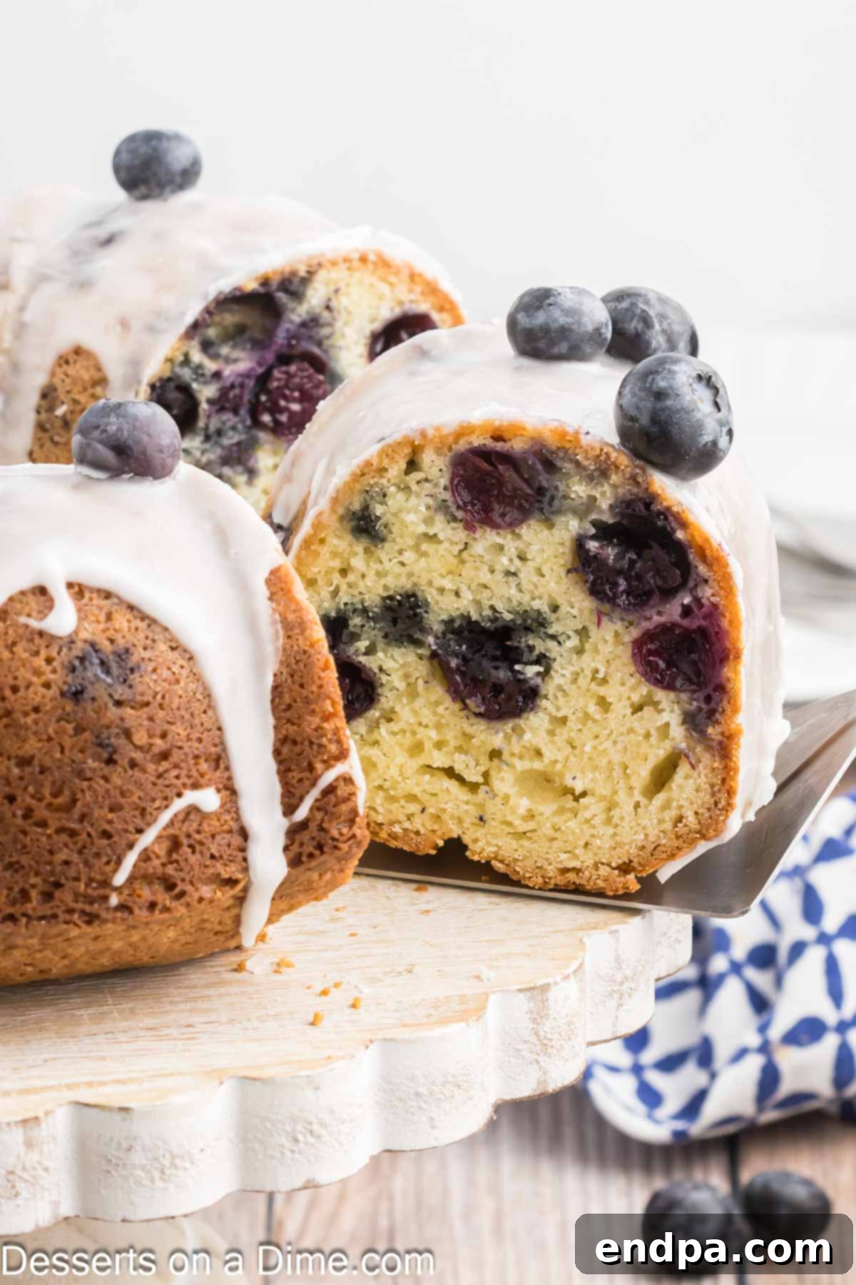 Sapphire Swirl Cake 2 A freshly sliced Blueberry Bundt Cake, showcasing its moist interior filled with blueberries and topped with a sweet glaze.