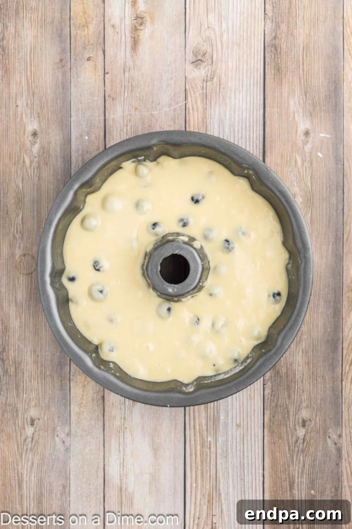 Sapphire Swirl Cake 7 Blueberry bundt cake batter being poured into a greased and floured bundt pan.