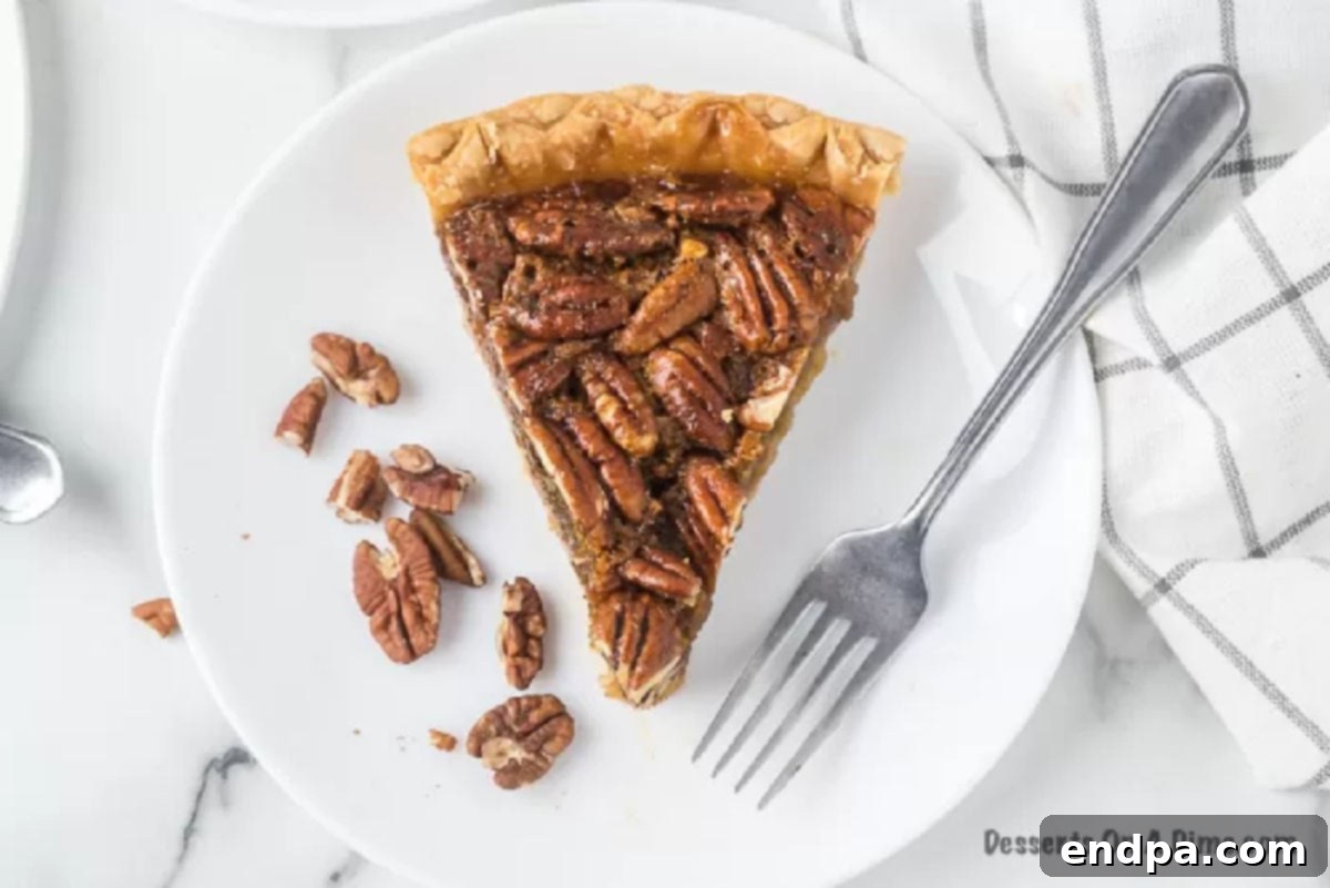 A perfectly baked slice of pecan pie on a white plate, showcasing its golden crust and rich, nutty filling.