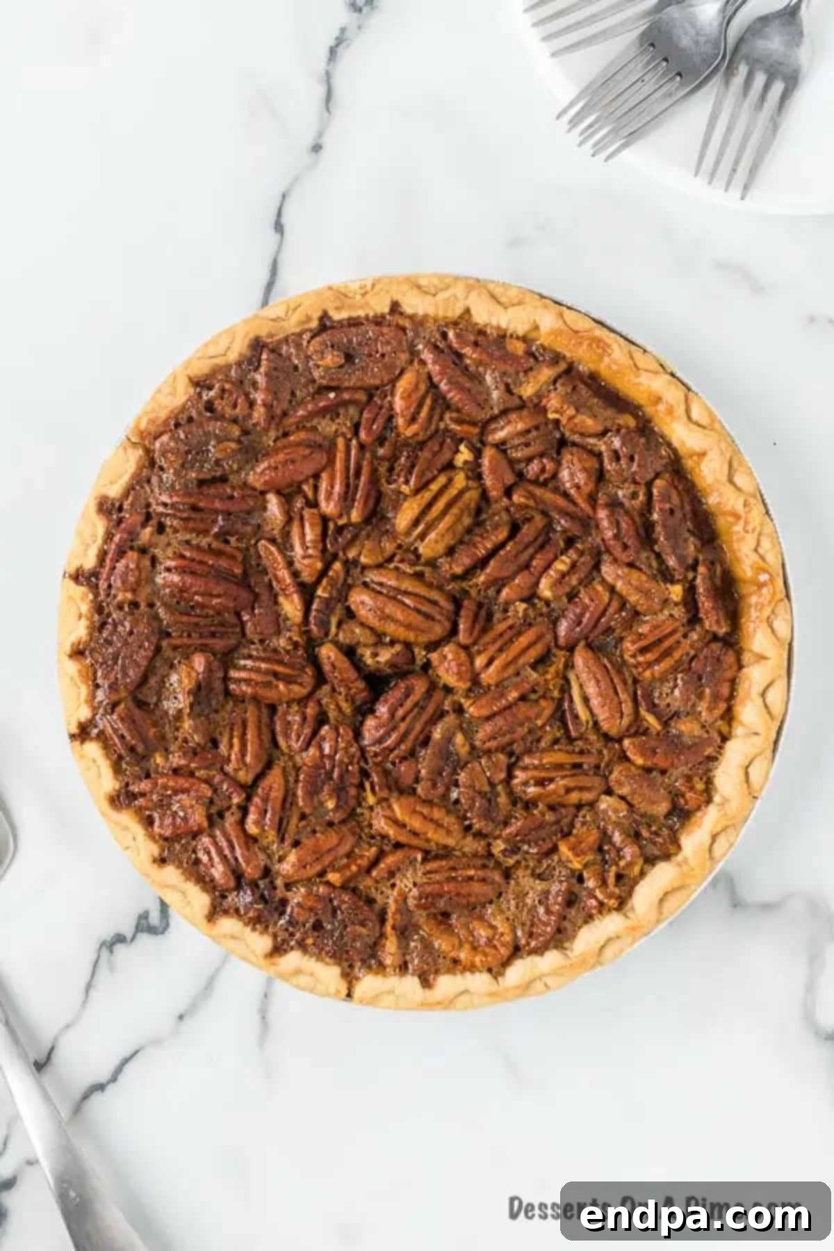 A freshly baked pecan pie cooling on a wire rack, with a rich golden-brown top.
