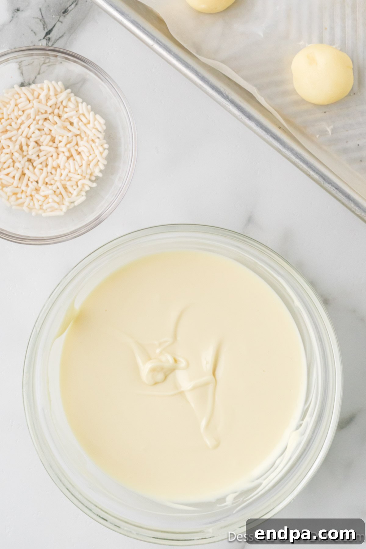 Melted white chocolate in a microwave-safe bowl, smooth and ready for dipping.