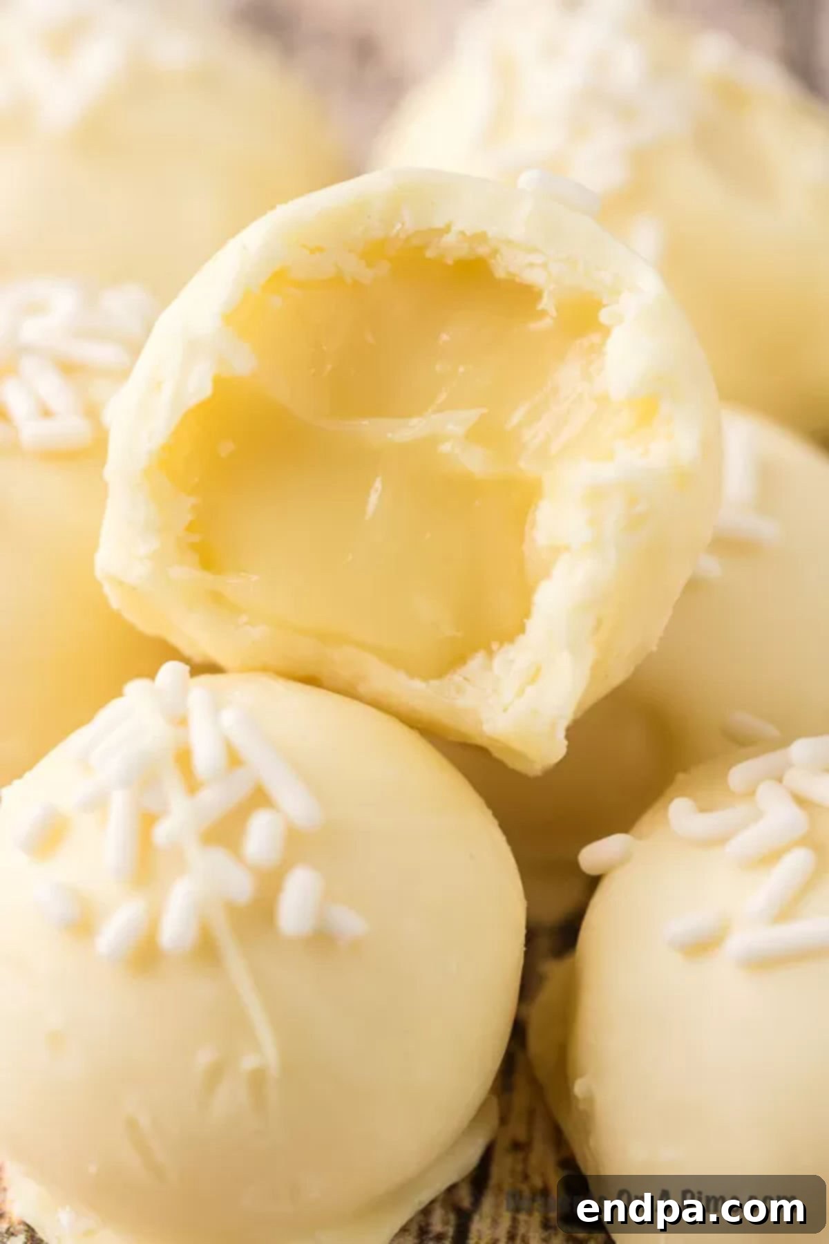 A close-up shot of a plate of perfectly coated White Chocolate Truffles with white sprinkles, ready to serve.