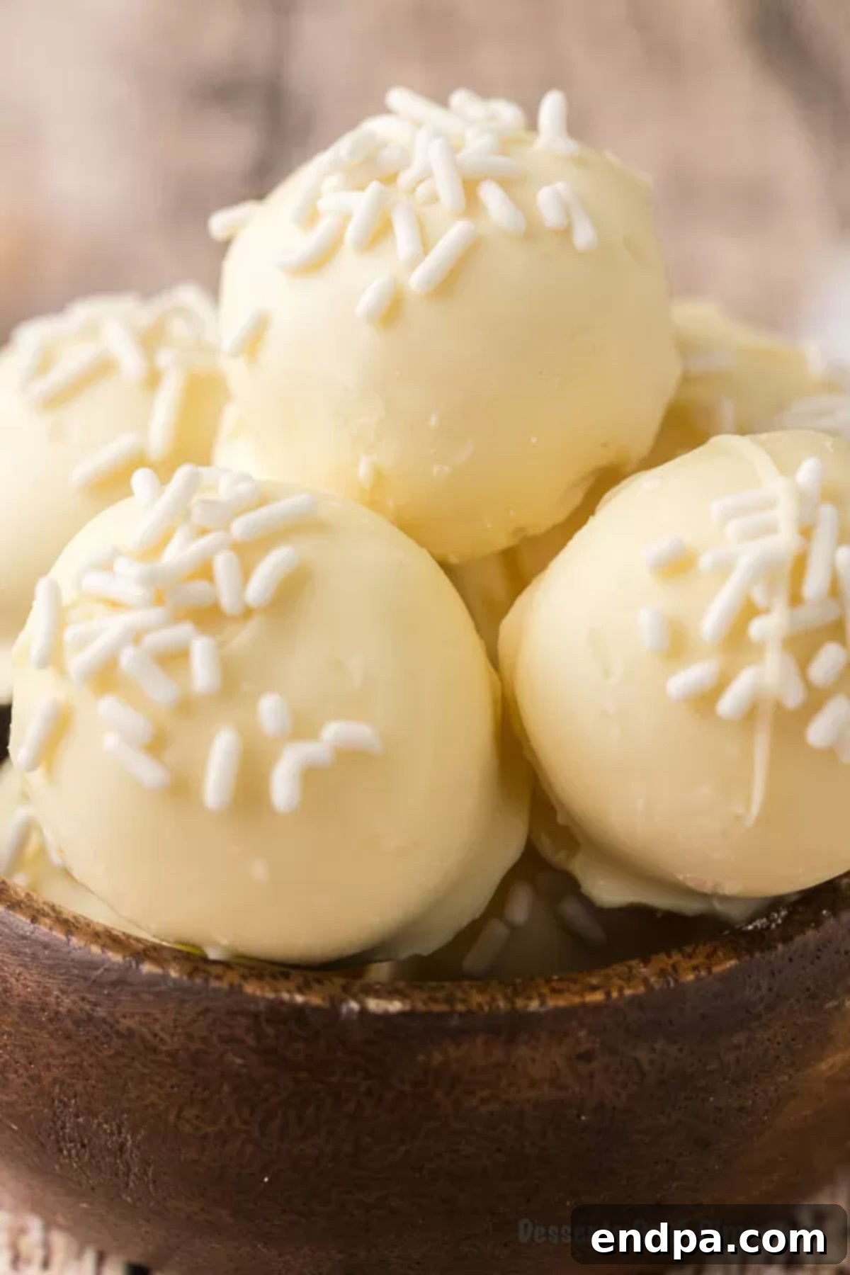 An artistic display of white chocolate truffles arranged on a clean white surface, showcasing their elegant simplicity.