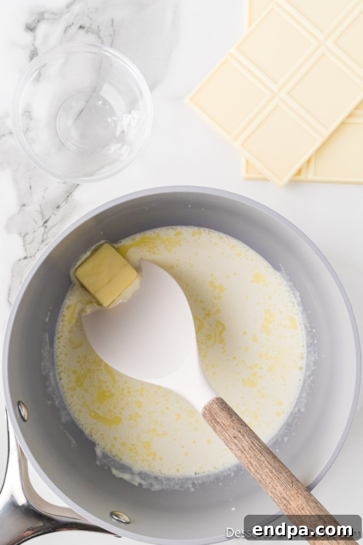 The butter is melting into the heavy cream, creating a smooth, rich mixture in the saucepan.