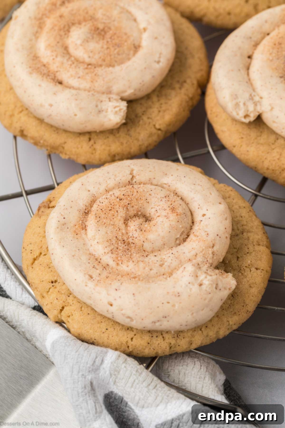 Spanish Cinnamon Sugar Cookies 2 Churro Cookies topped with frosting on a wire rack.