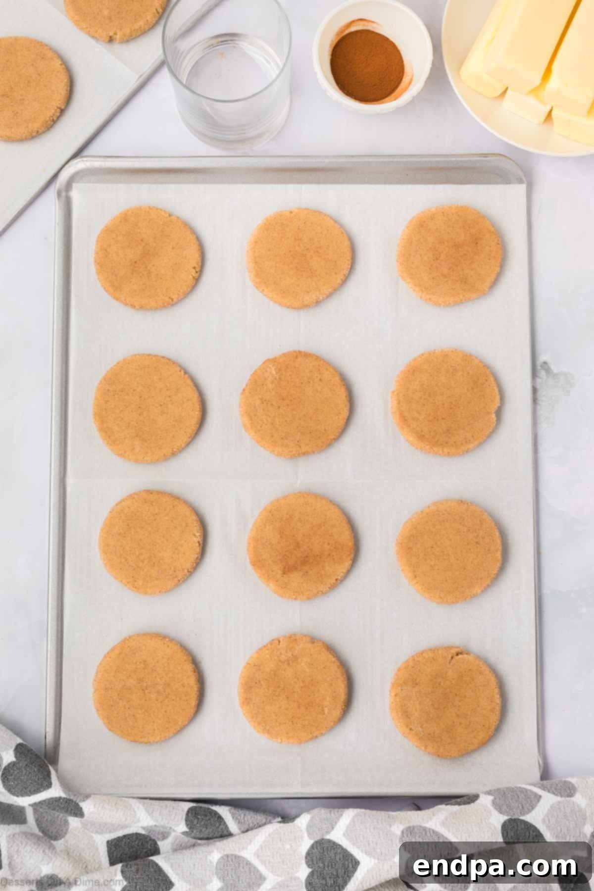 Spanish Cinnamon Sugar Cookies 12 Cookies flattened on baking sheet.
