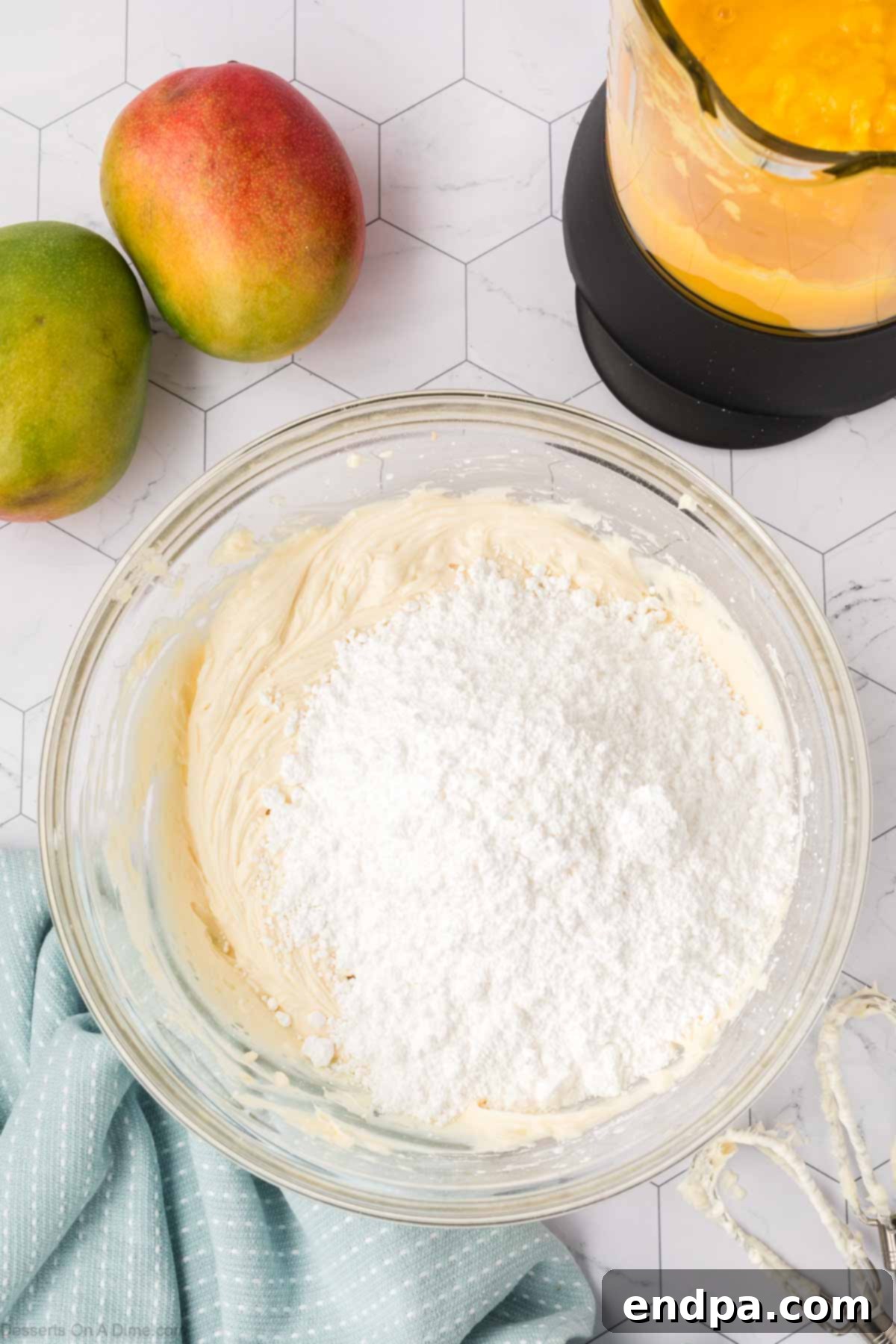 Cream cheese, unsalted butter, powdered sugar, and vanilla extract combined in a mixing bowl for the cream cheese frosting.