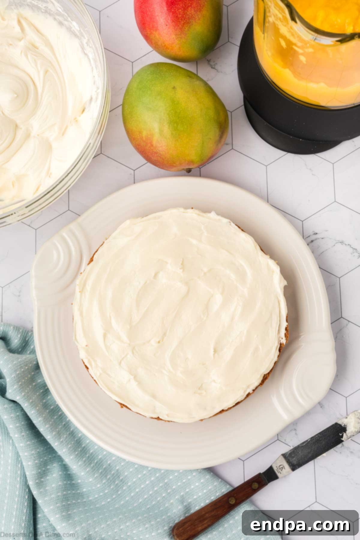 A smooth layer of cream cheese frosting spread evenly on the first cake layer.