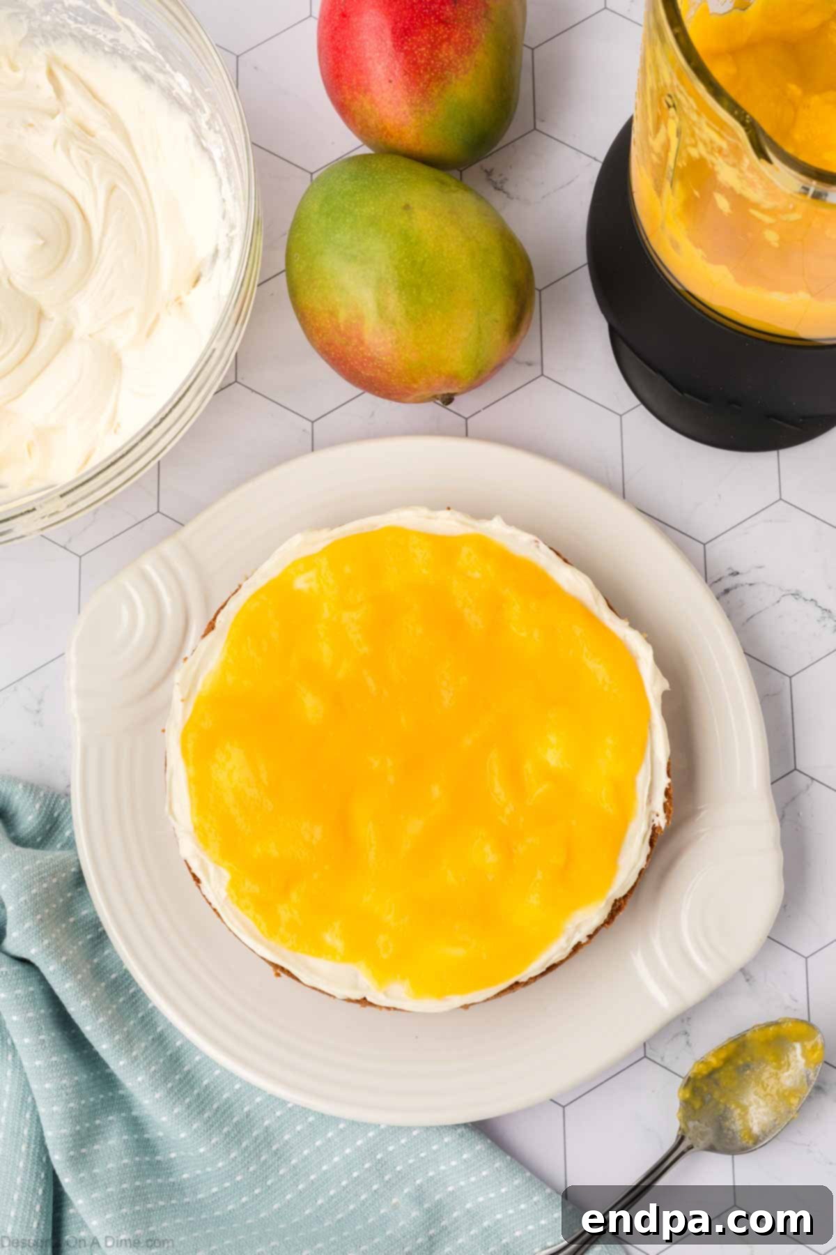 Vibrant mango puree spread over the layer of cream cheese frosting on the cake.