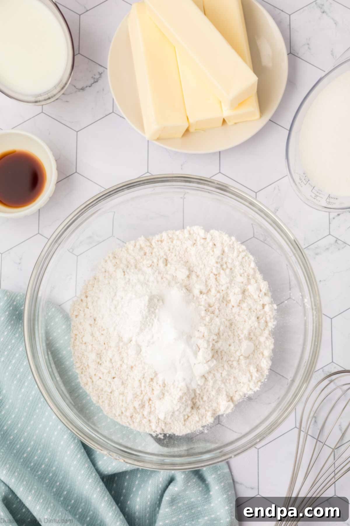 Dry ingredients for cake in a mixing bowl, including cake flour, baking powder, baking soda, and salt.