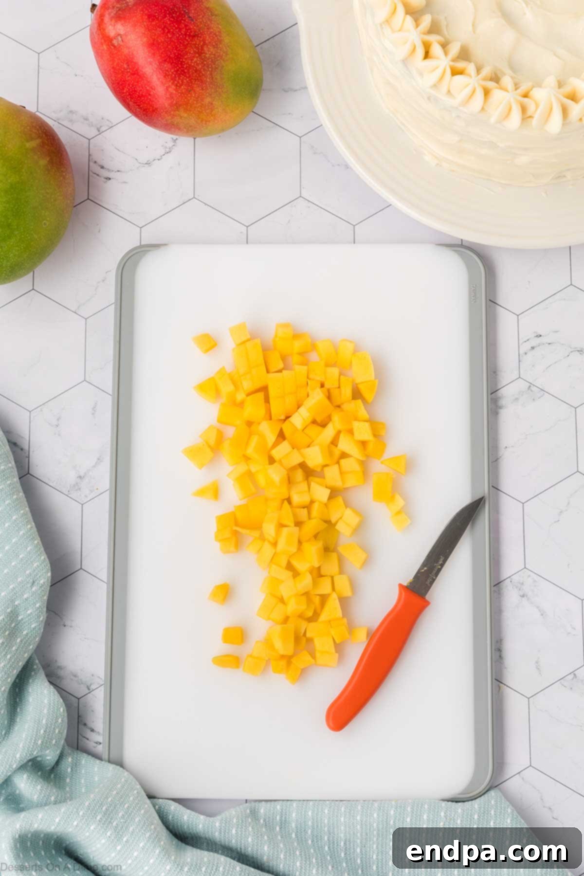 Fresh mangoes cut into small, uniform cubes, ready to be placed on top of the cake as a garnish.