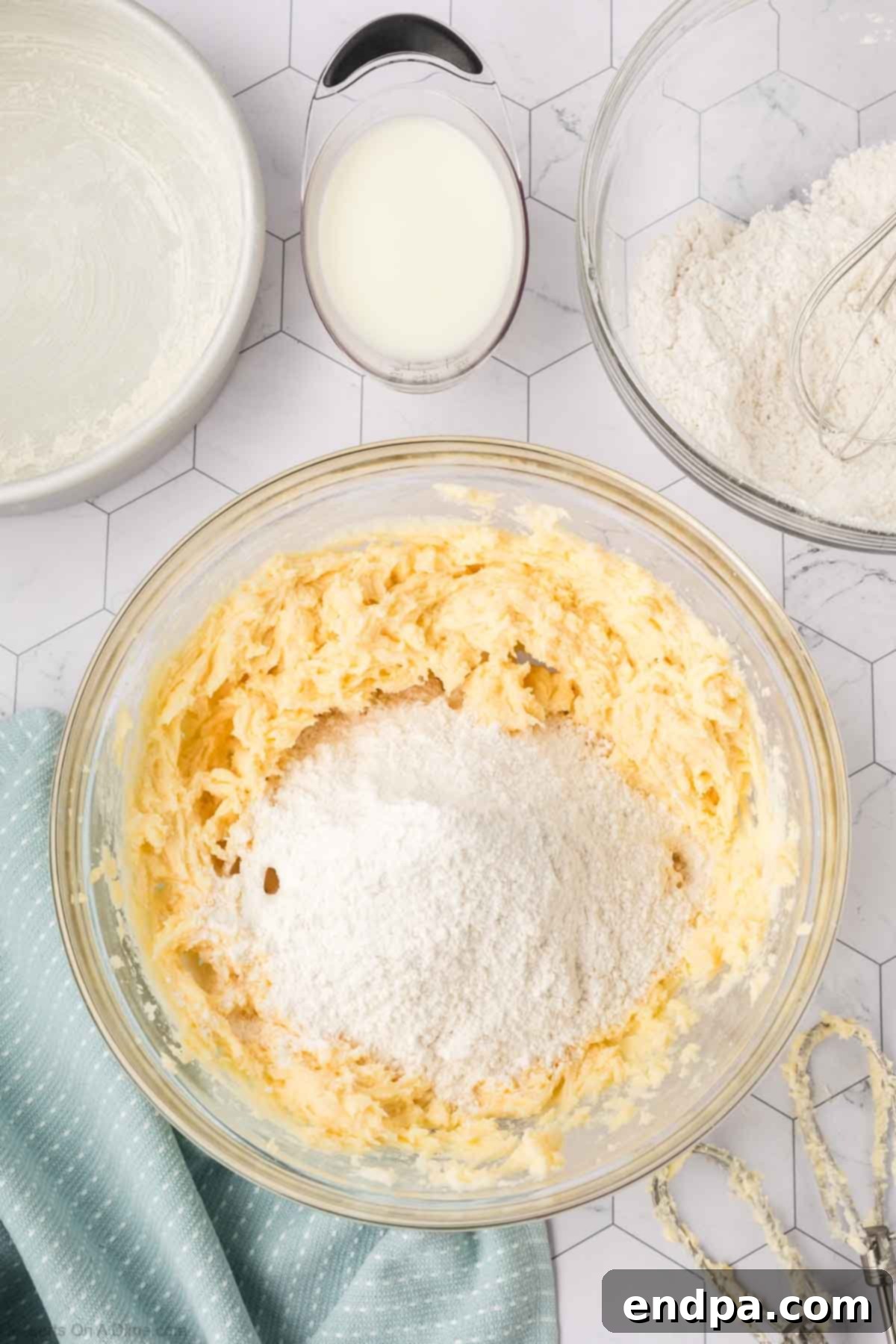 Alternating additions of dry flour mixture and buttermilk to the wet ingredients, creating a smooth cake batter.