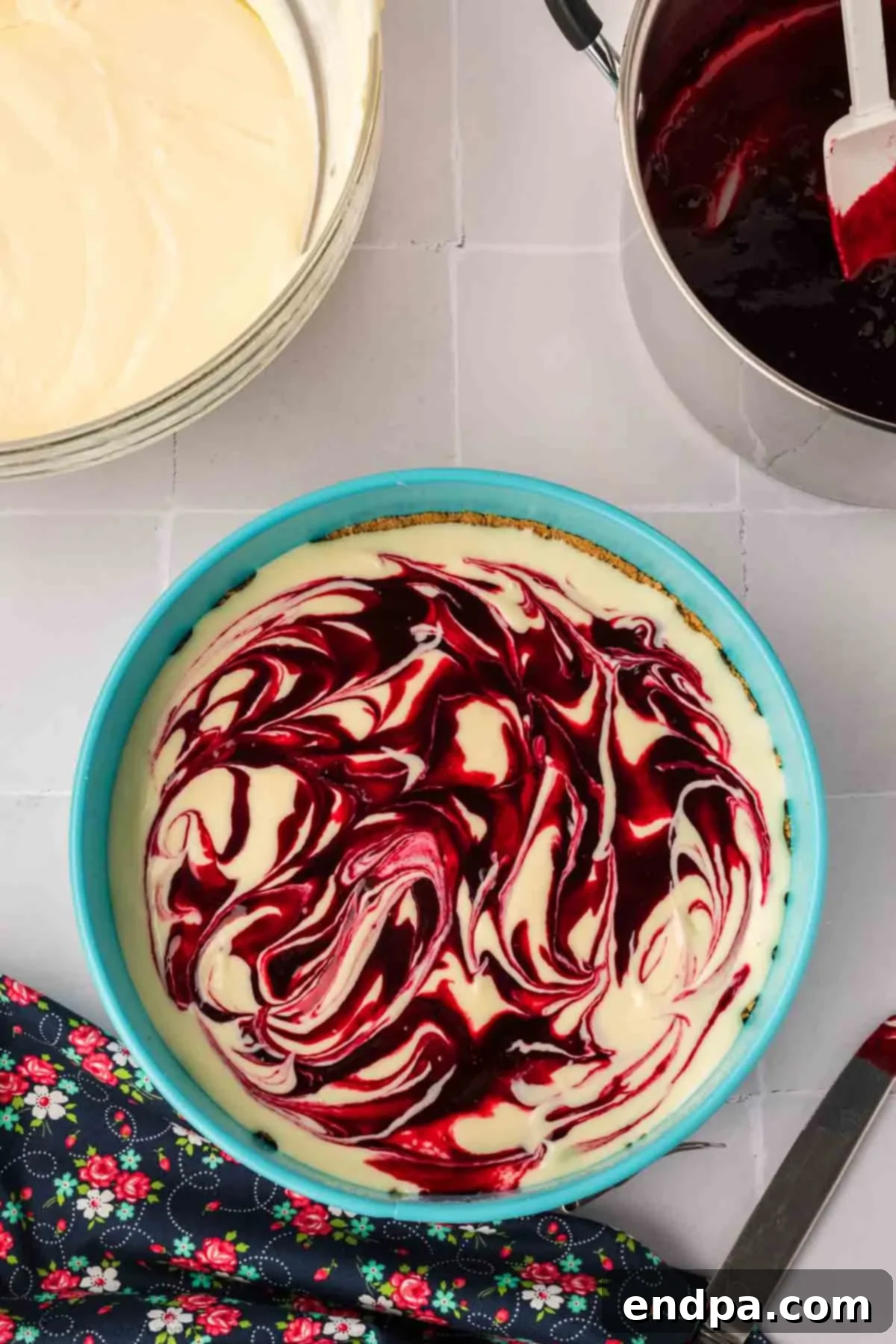 Remaining cheesecake batter poured over the first swirled layer, with the rest of the blackberry puree added and gently swirled on top.