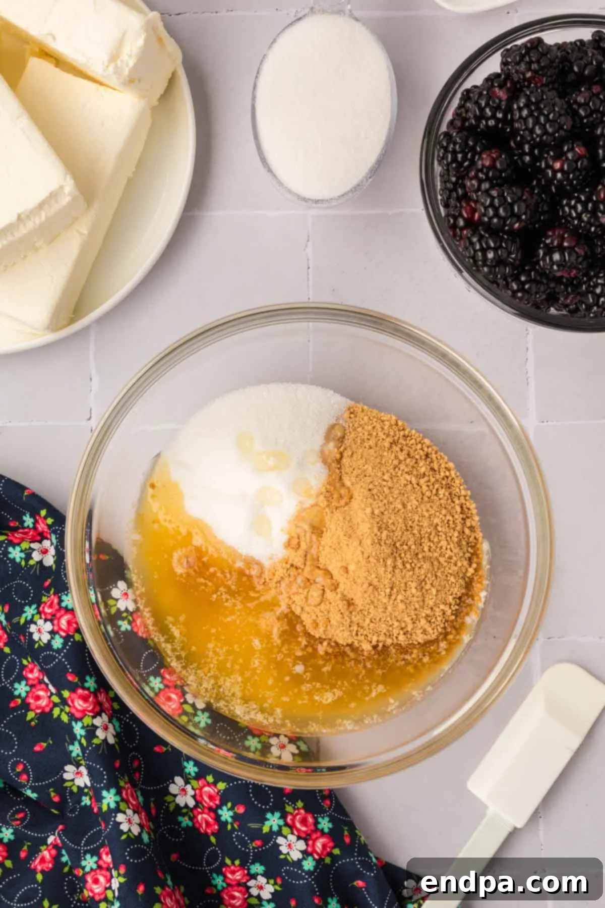 Crushed graham crackers, melted butter, and sugar mixed together in a large bowl, ready for forming the cheesecake crust.