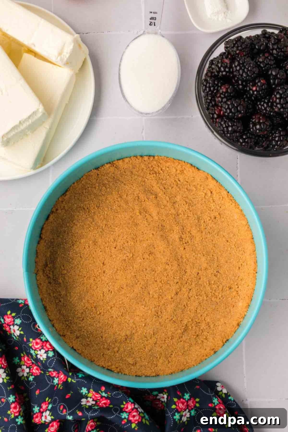 The graham cracker crust mixture firmly pressed into the bottom and slightly up the sides of a 9-inch springform pan.