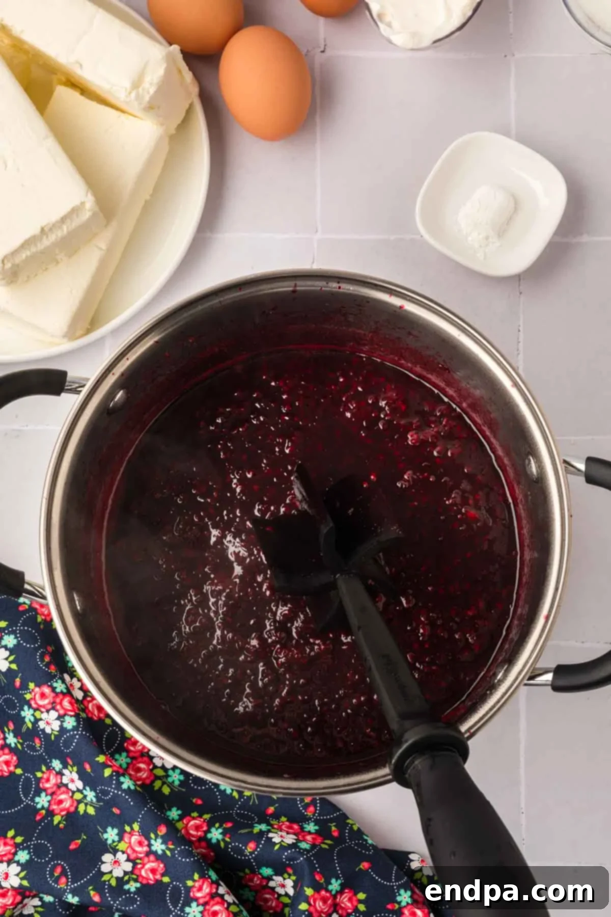 Blackberry mixture simmering in a saucepan, cooked down into a rich, dark sauce with softened berries.