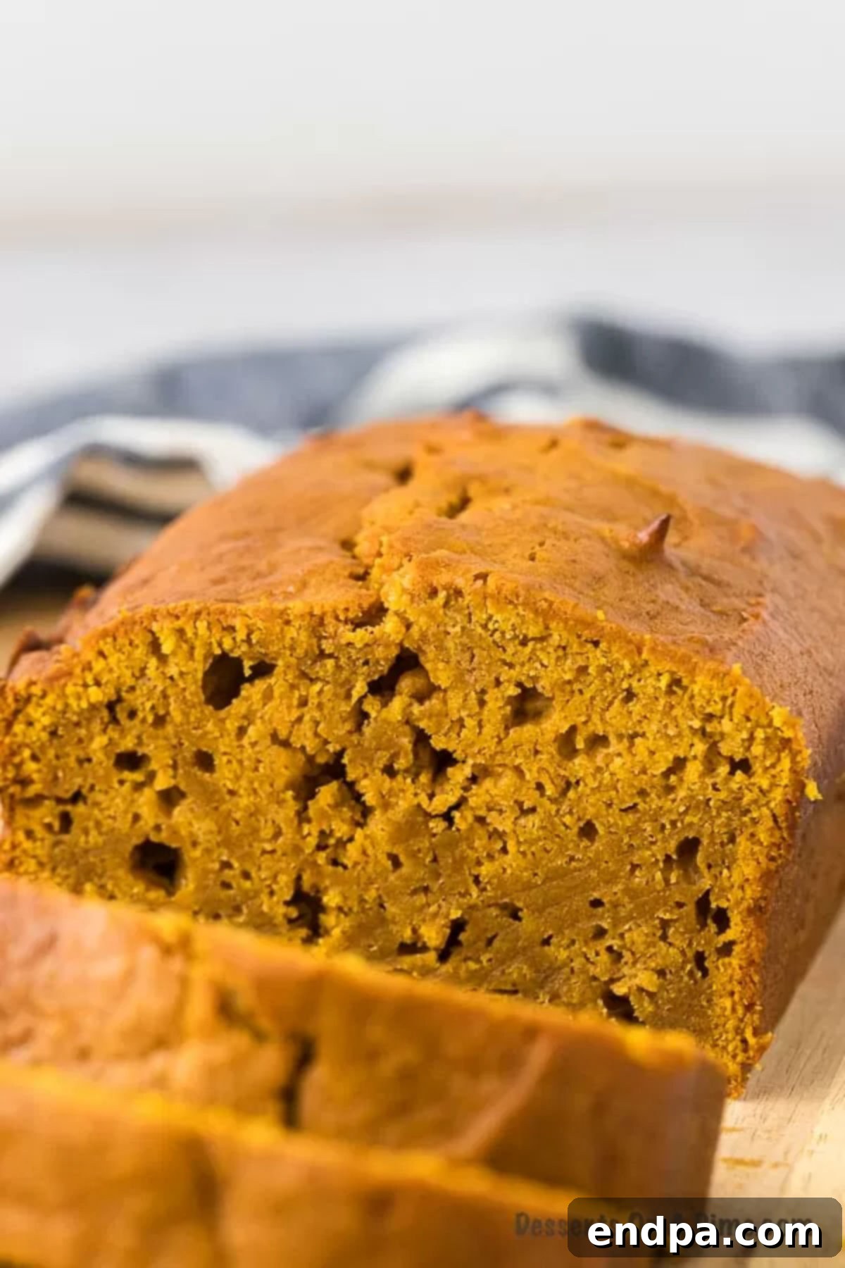 Loaf of pumpkin bread sliced on a cutting board