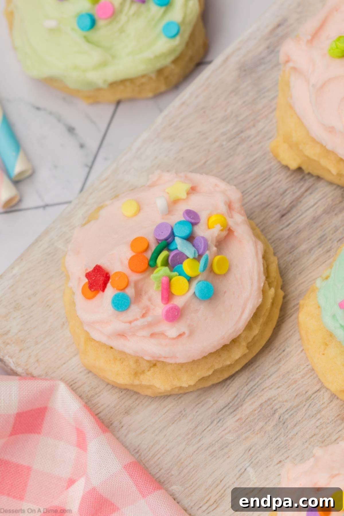 Cloud-Soft Sour Cream Cookies 2 Soft and cakey Sour Cream Sugar Cookies adorned with colorful frosting and festive sprinkles, arranged beautifully on a serving platter.