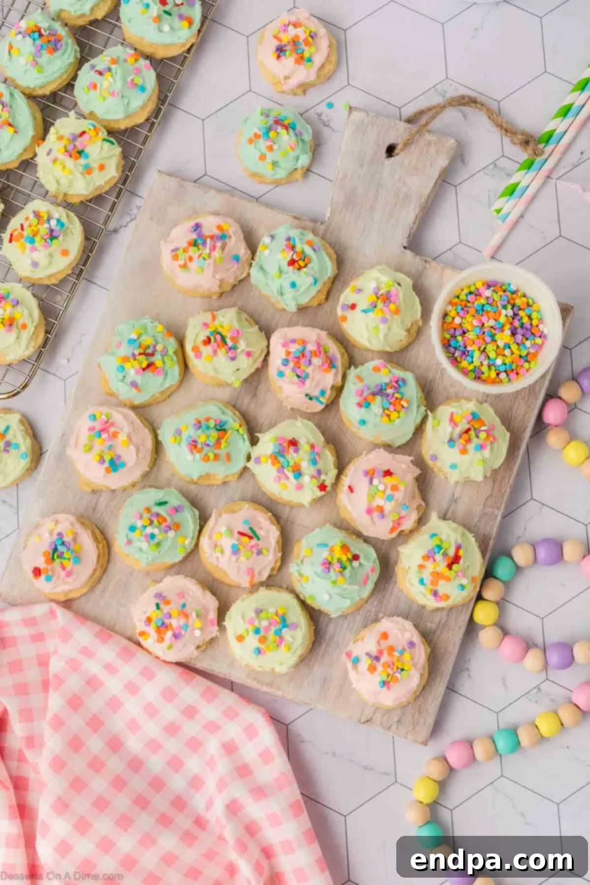 Cloud-Soft Sour Cream Cookies 15 Sour cream sugar cookies, generously frosted with buttercream and topped with sprinkles, artfully arranged on a cooling rack.