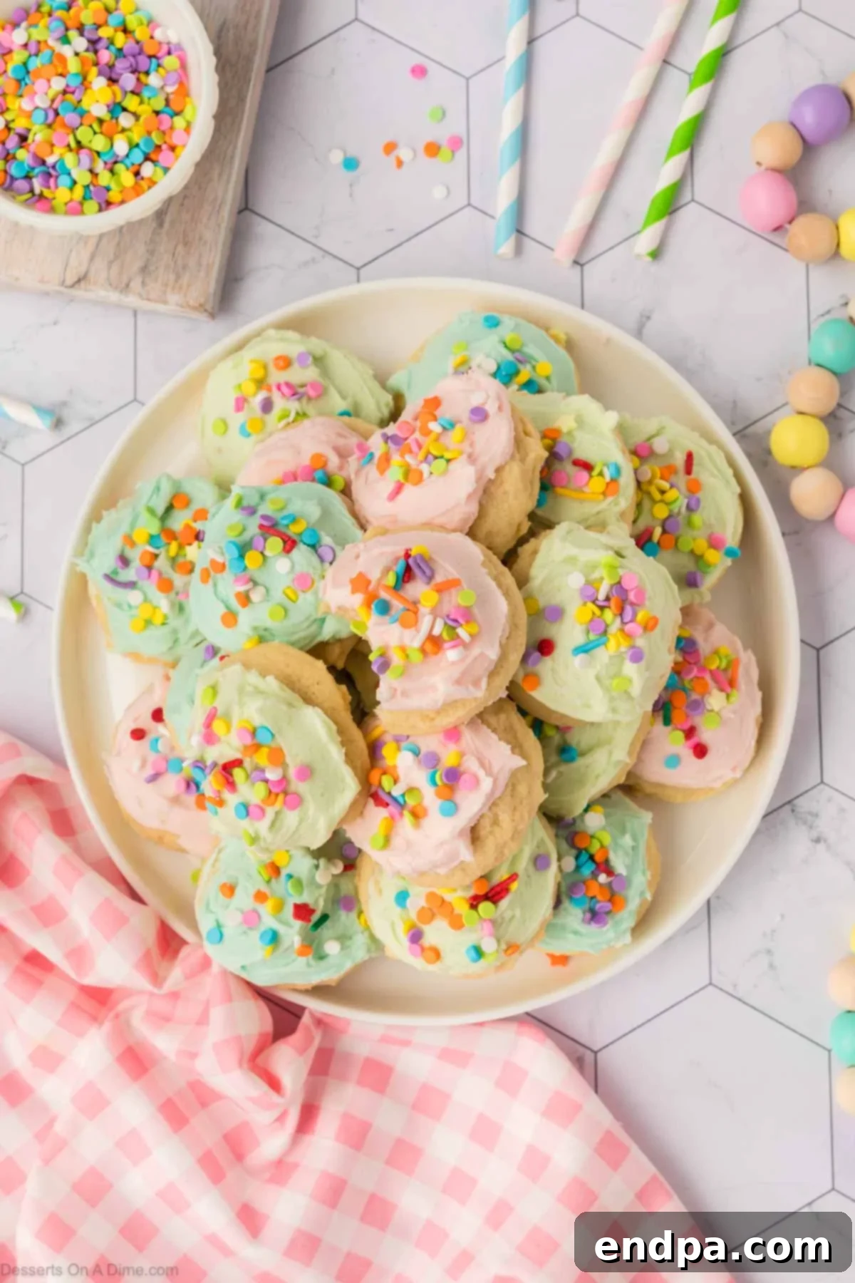 Cloud-Soft Sour Cream Cookies 16 A beautiful platter of frosted Sour Cream Sugar Cookies, adorned with sprinkles, ready to be enjoyed as a delightful dessert.