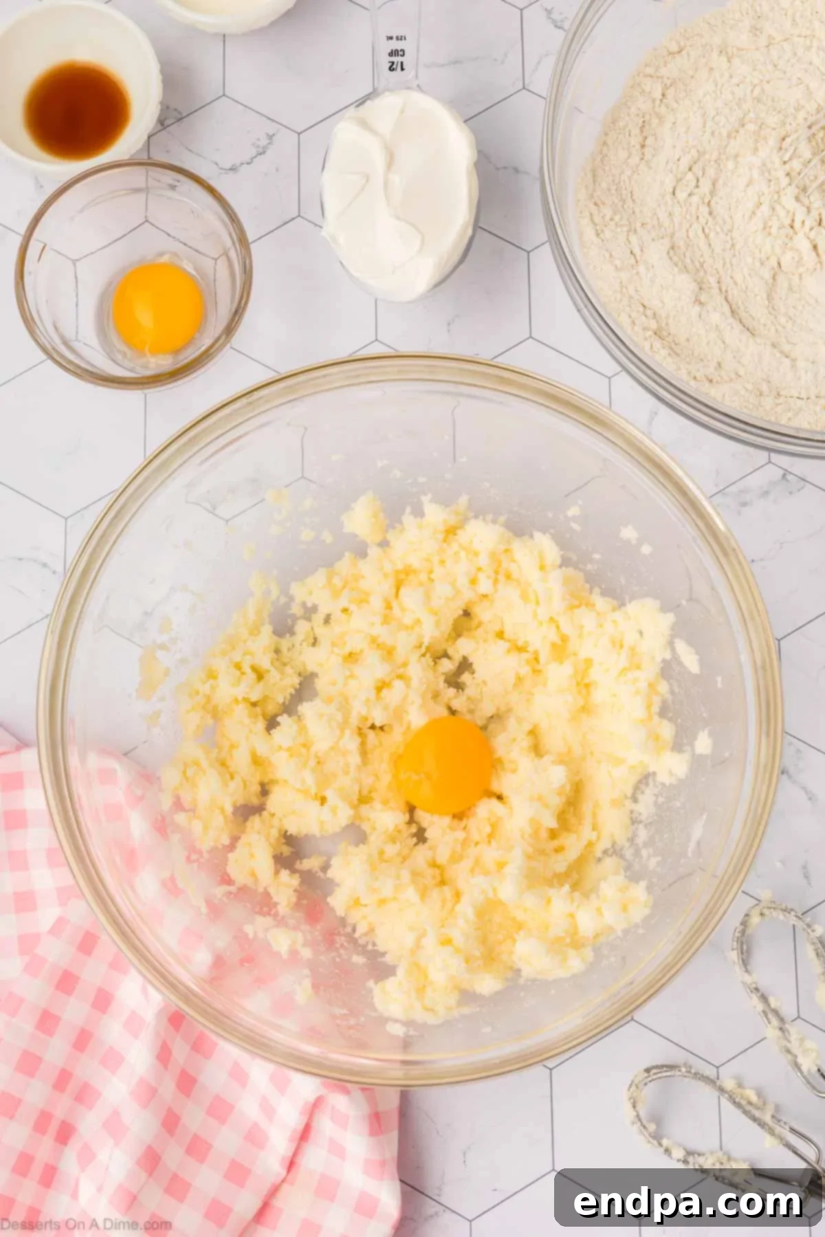 Cloud-Soft Sour Cream Cookies 5 Egg yolks being incorporated one at a time into the creamed butter and sugar mixture.