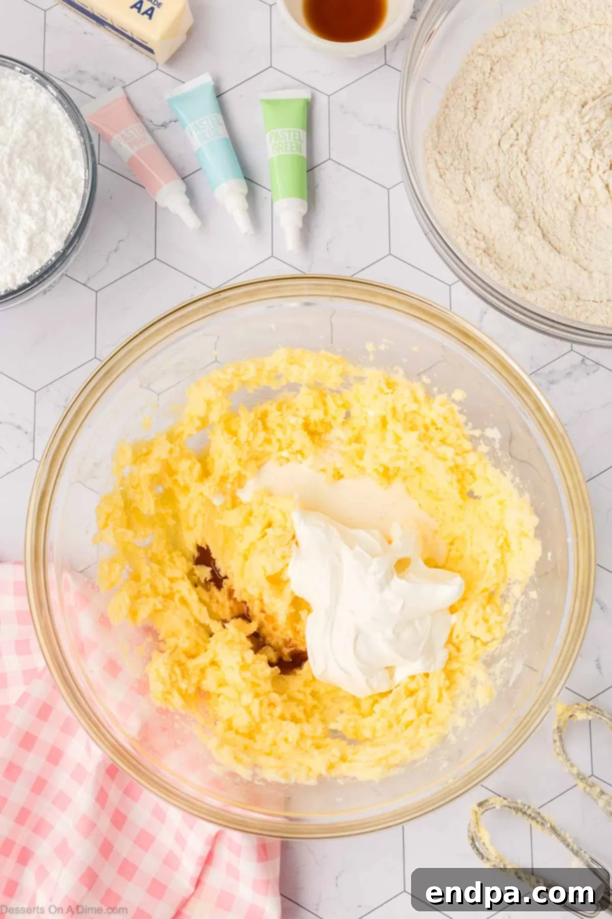 Cloud-Soft Sour Cream Cookies 6 Sour cream, vanilla extract, and heavy cream being added to the wet ingredients in a mixing bowl.