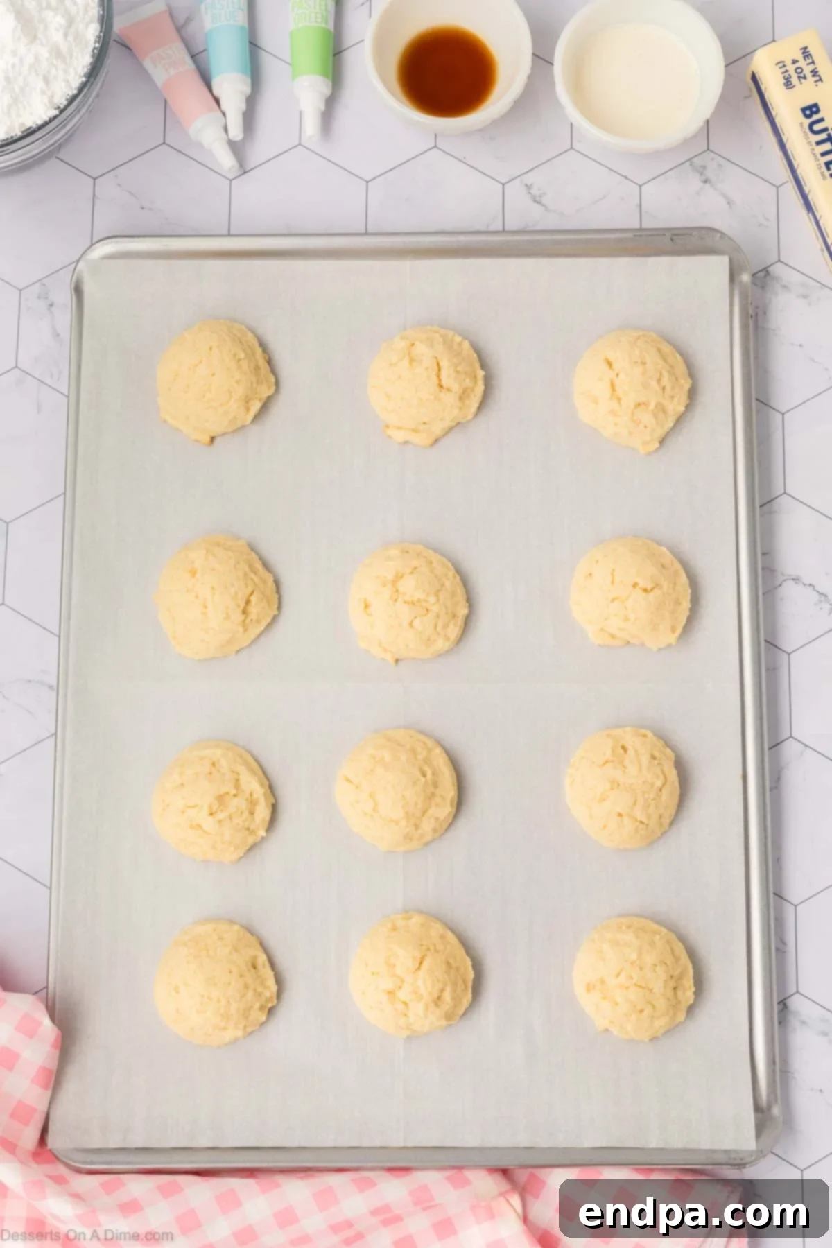 Cloud-Soft Sour Cream Cookies 10 Evenly scooped cookie dough balls placed on a parchment-lined baking sheet, ready for the oven.