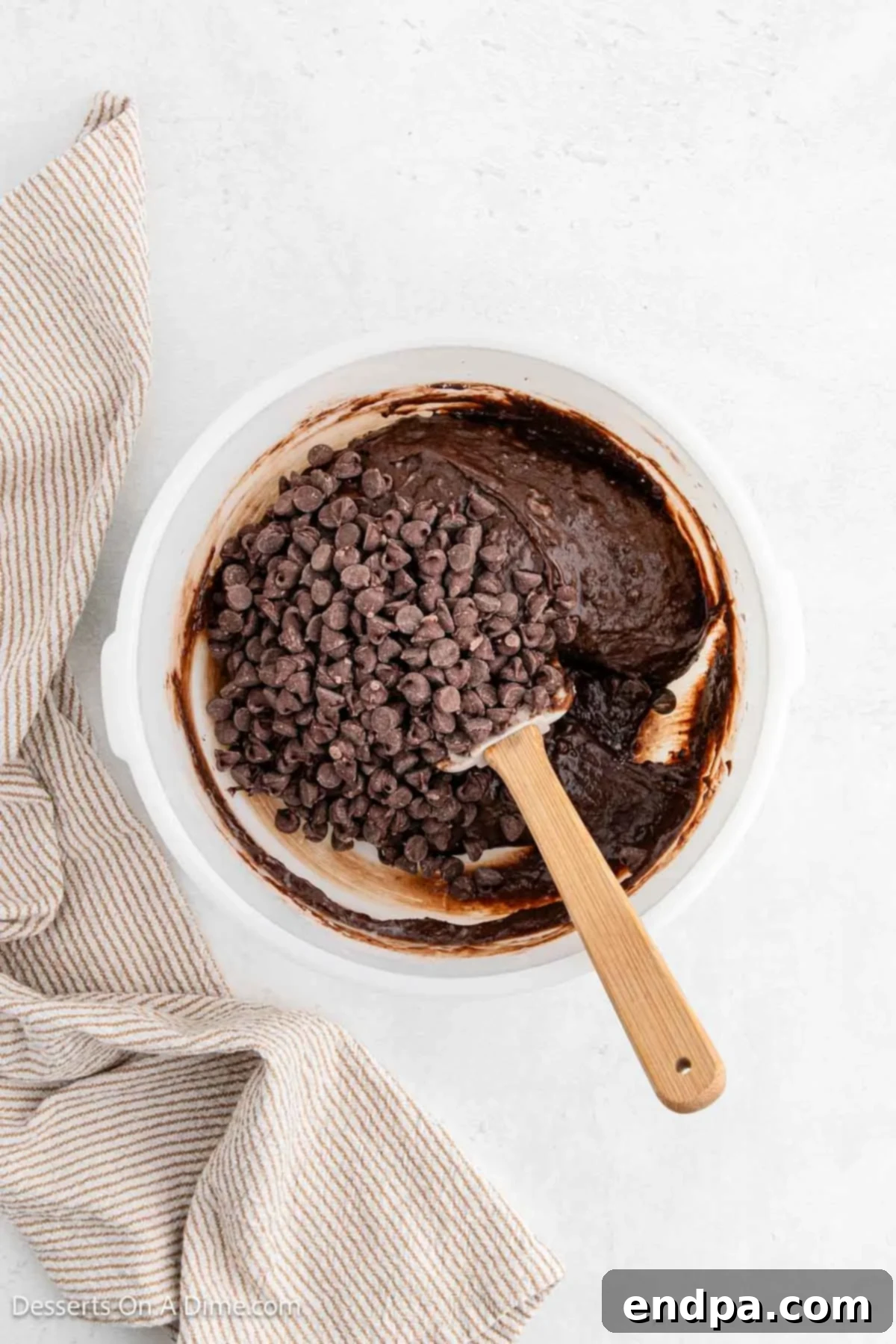 Semi-sweet chocolate chips being folded into the brownie batter.