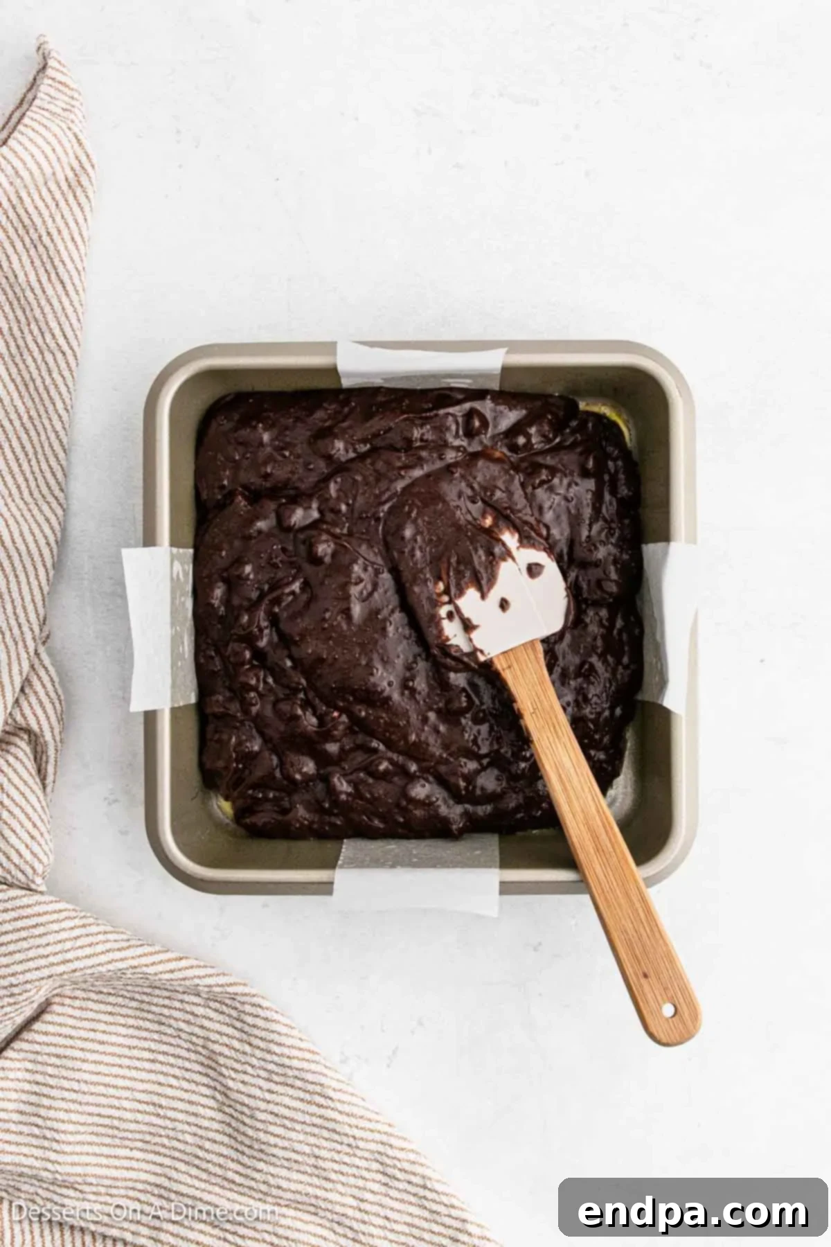 Brownie batter evenly spread into the prepared 8x8 inch baking dish.