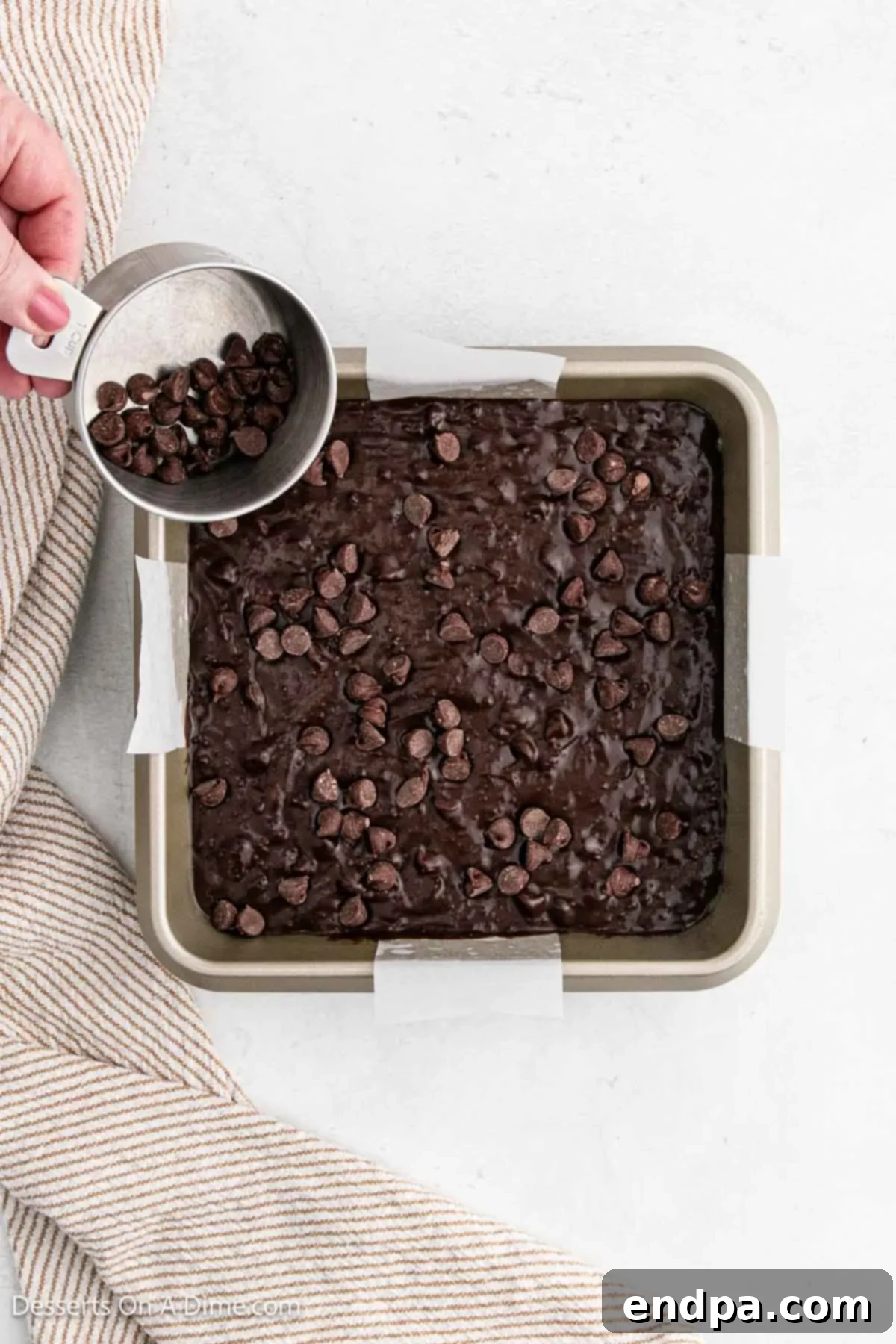 Additional chocolate chips sprinkled generously on top of the brownie batter before baking.