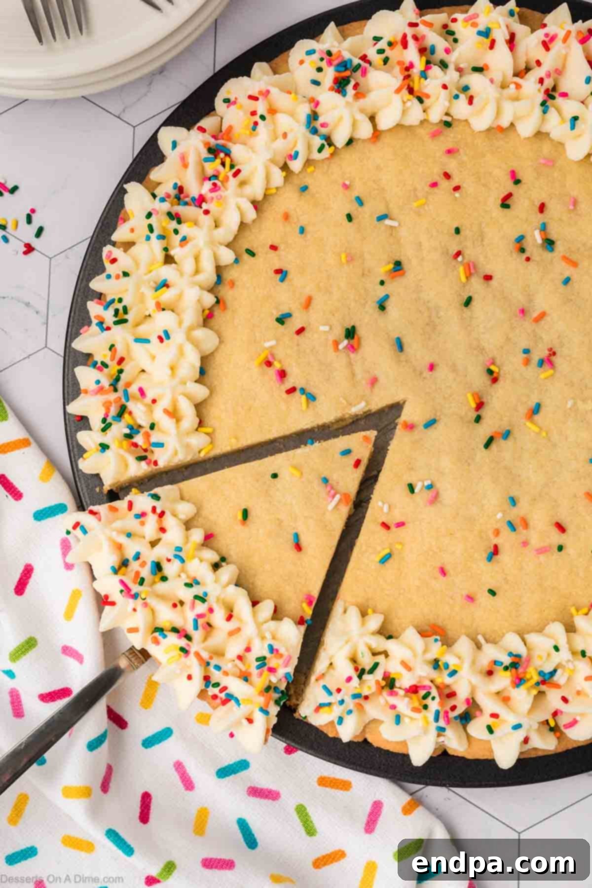 A freshly baked Sugar Cookie Cake being sliced, showing its soft texture and creamy frosting.