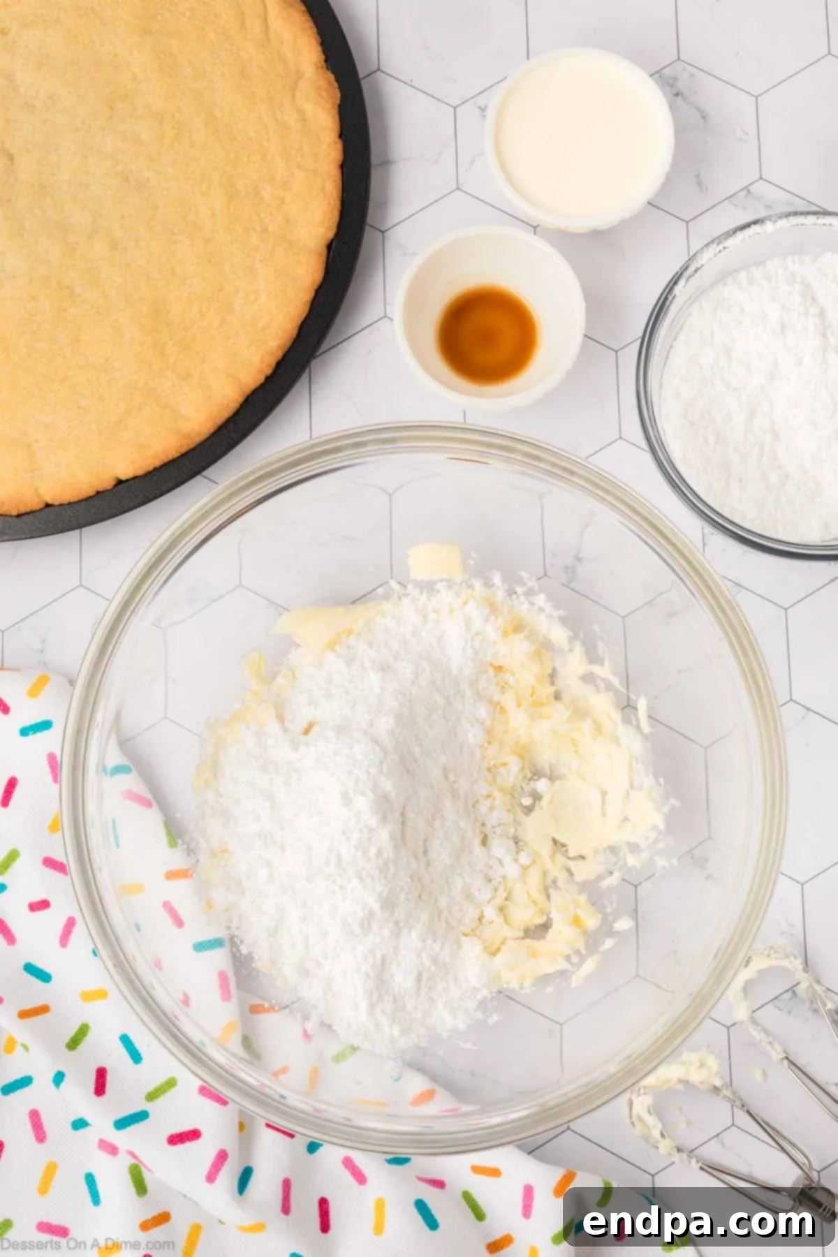Softened butter in a mixing bowl, freshly beaten, with powdered sugar gradually being added to make the creamy buttercream frosting.