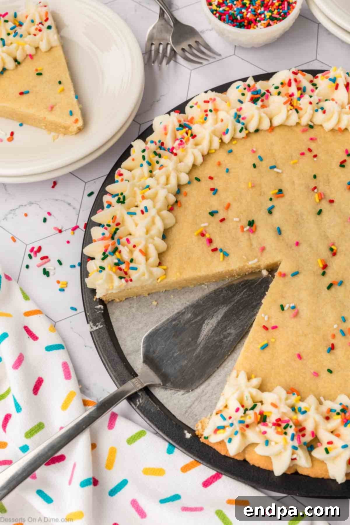 A slice being carefully cut from the decorated Sugar Cookie Cake, revealing its soft interior, ready to be served.