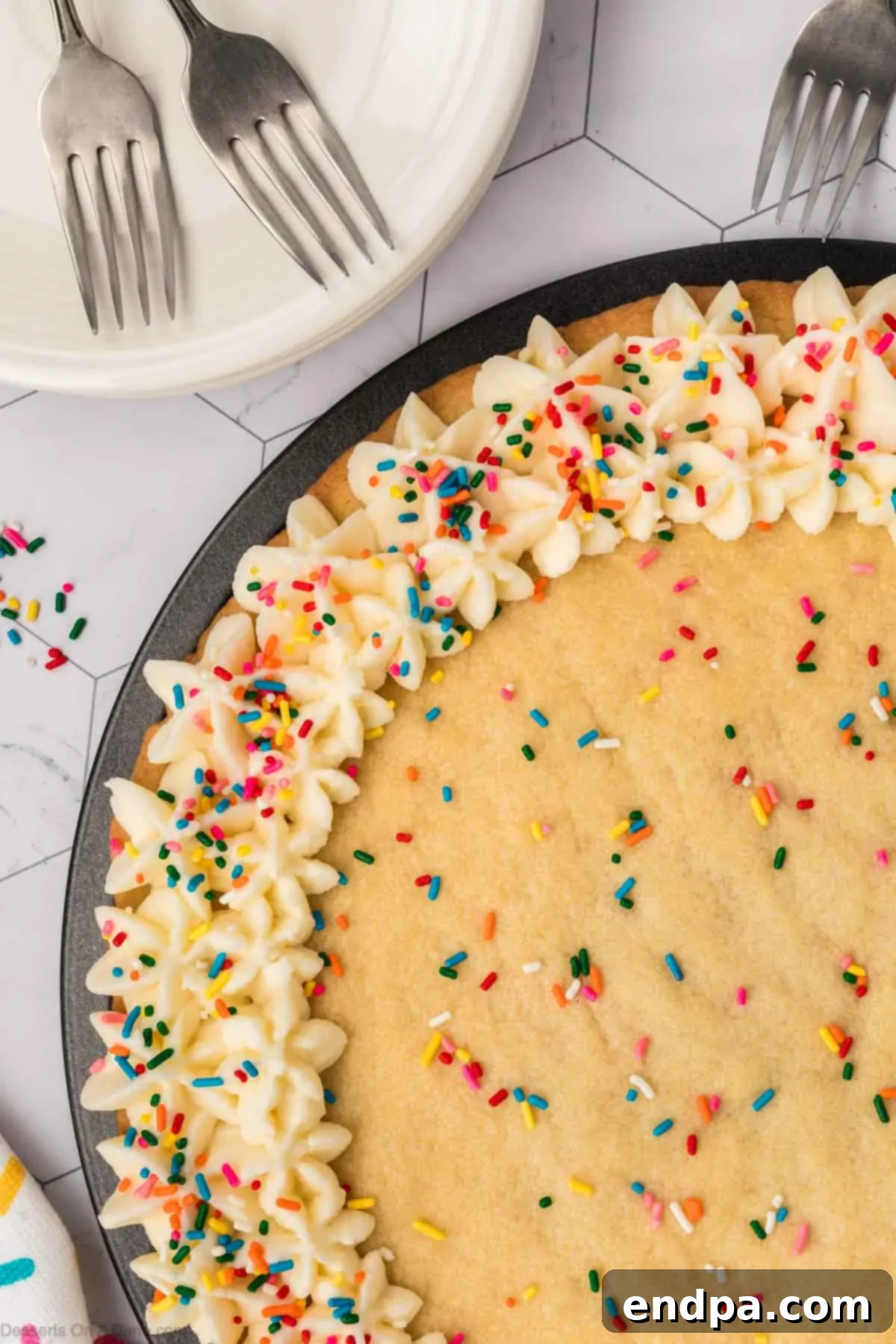 A completed Sugar Cookie Cake, beautifully decorated with frosting and colorful sprinkles, sitting on a serving platter, ready to be enjoyed.