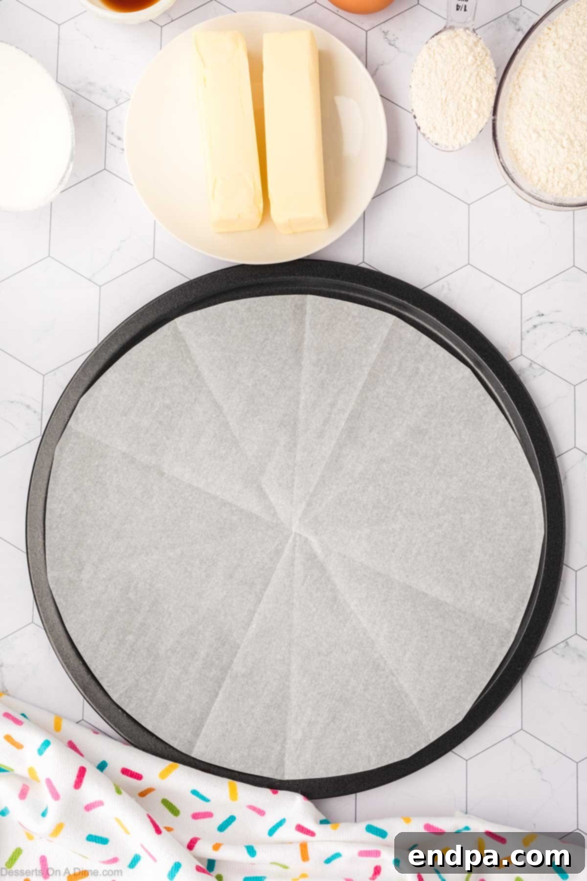 A 12-inch round cookie cake pan perfectly lined with parchment paper, ready for the dough.