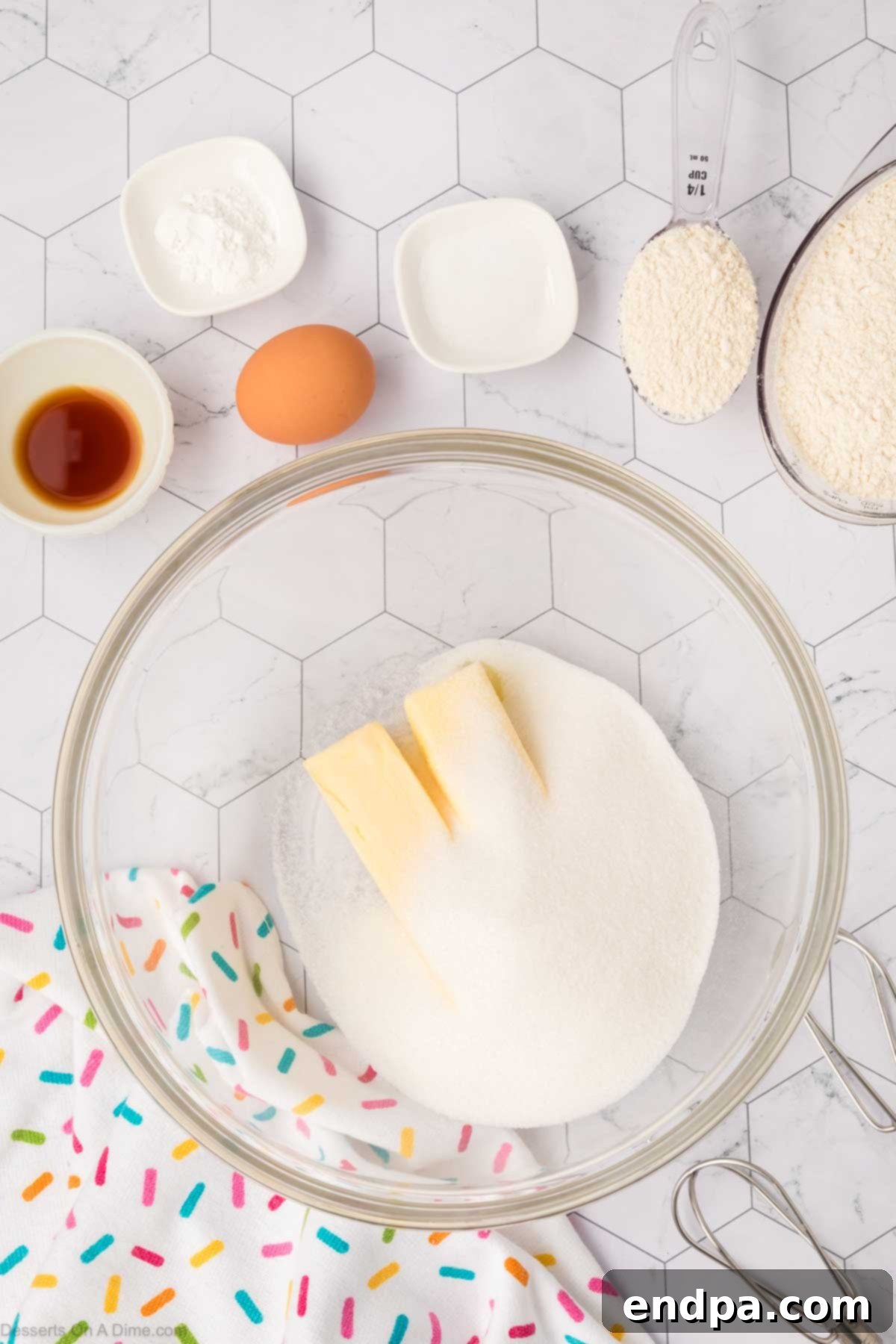 Granulated sugar and softened unsalted butter combined in a mixing bowl, looking light and fluffy after being creamed.