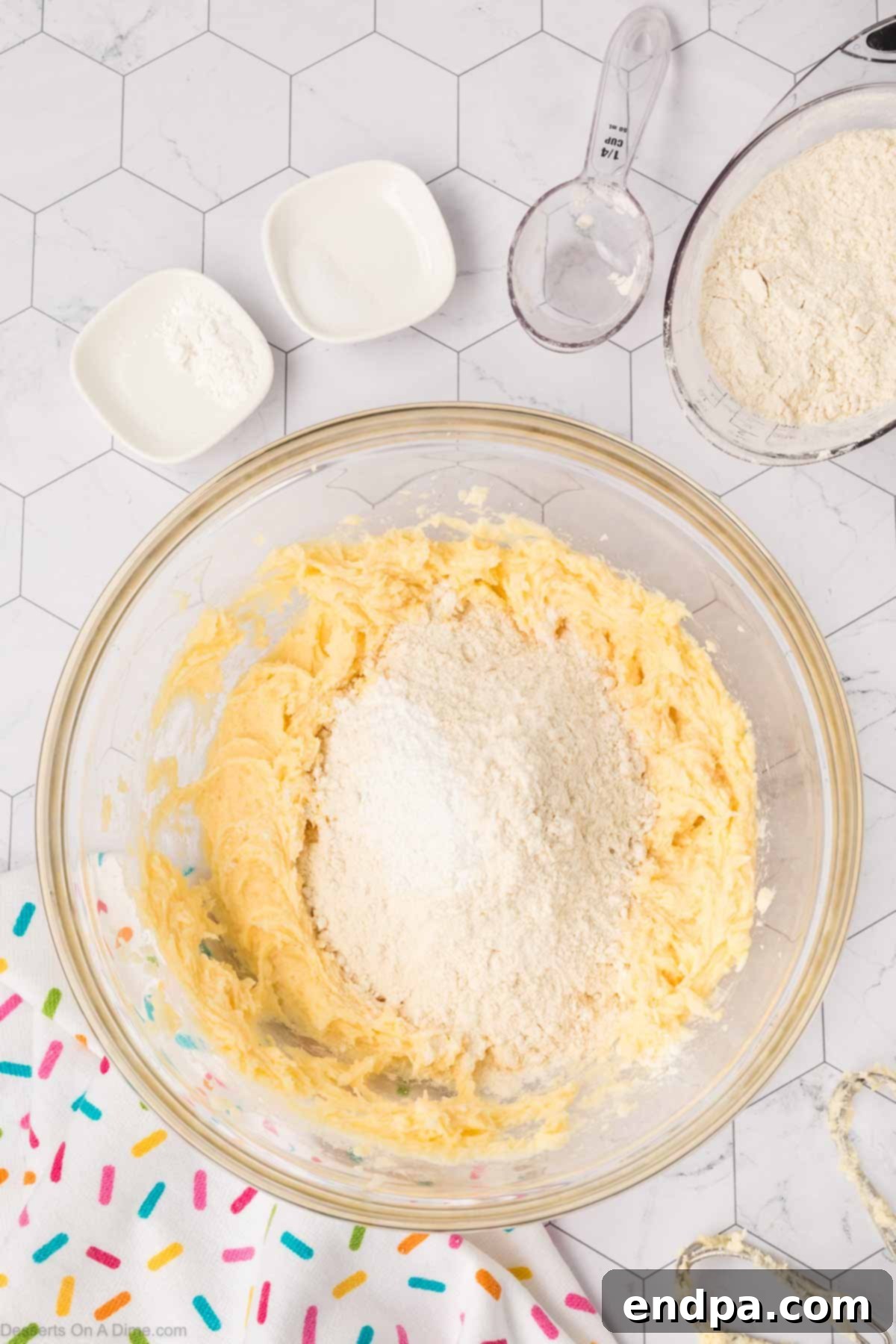 All-purpose flour, baking powder, and salt being slowly added to the wet ingredients in a mixing bowl, creating the cookie dough.