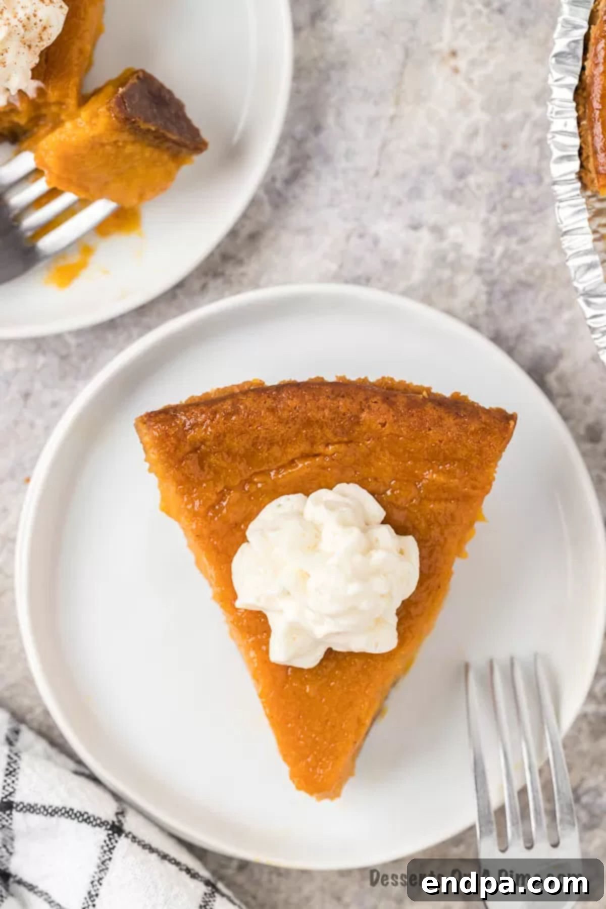 Slice of sweet potato pie on a plate with whipped cream
