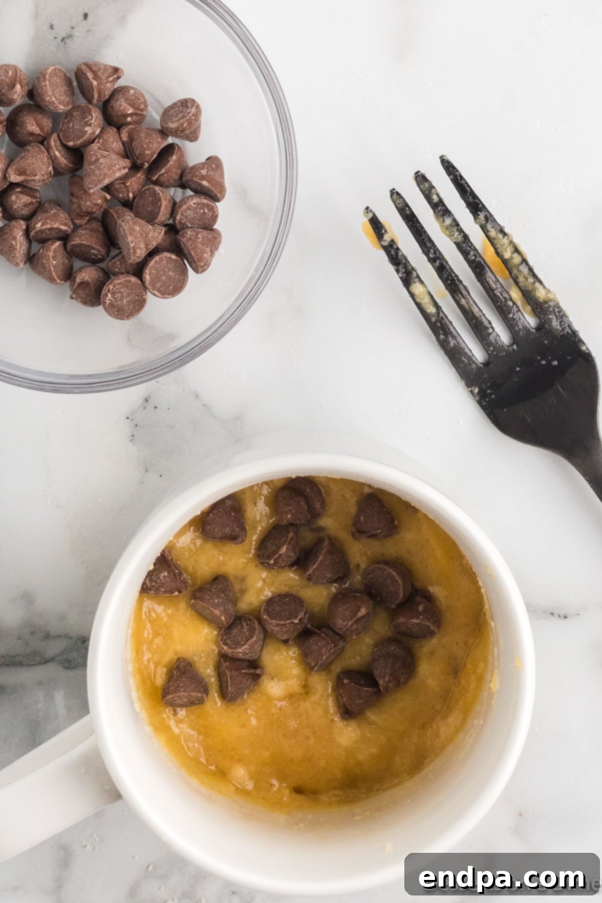 Heavenly Keto Chocolate Chip Mug Cake 6 Sugar-free chocolate chips added to the top of the mug cake batter.