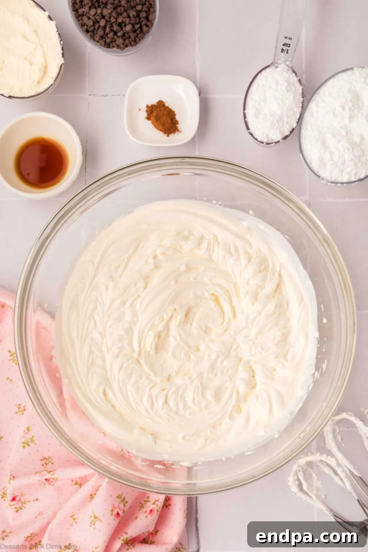 Ricotta cheese, powdered sugar, and cinnamon being mixed into the cream cheese and heavy cream mixture.