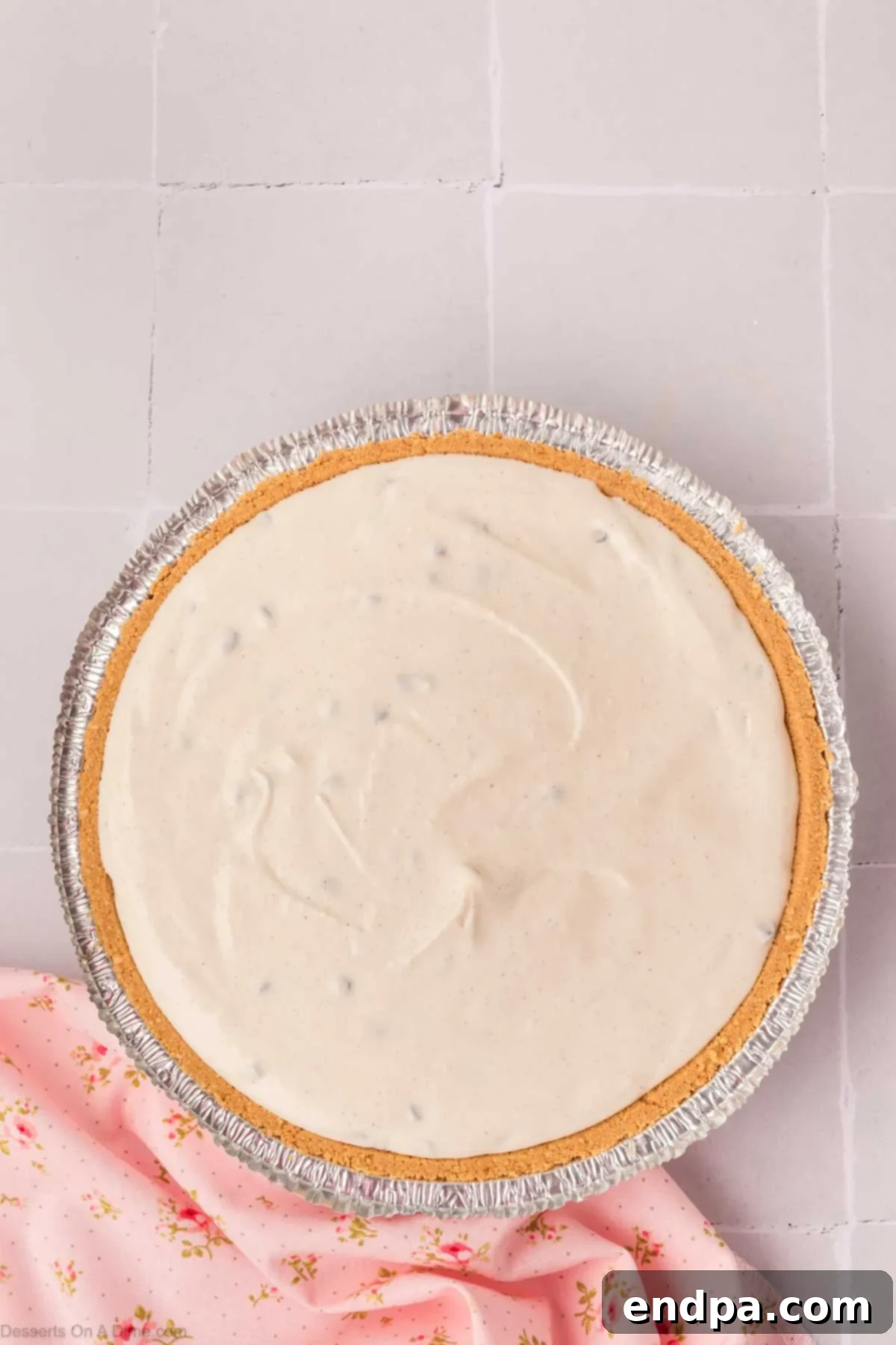 Cannoli pie filling being smoothly spread into a graham cracker pie crust.