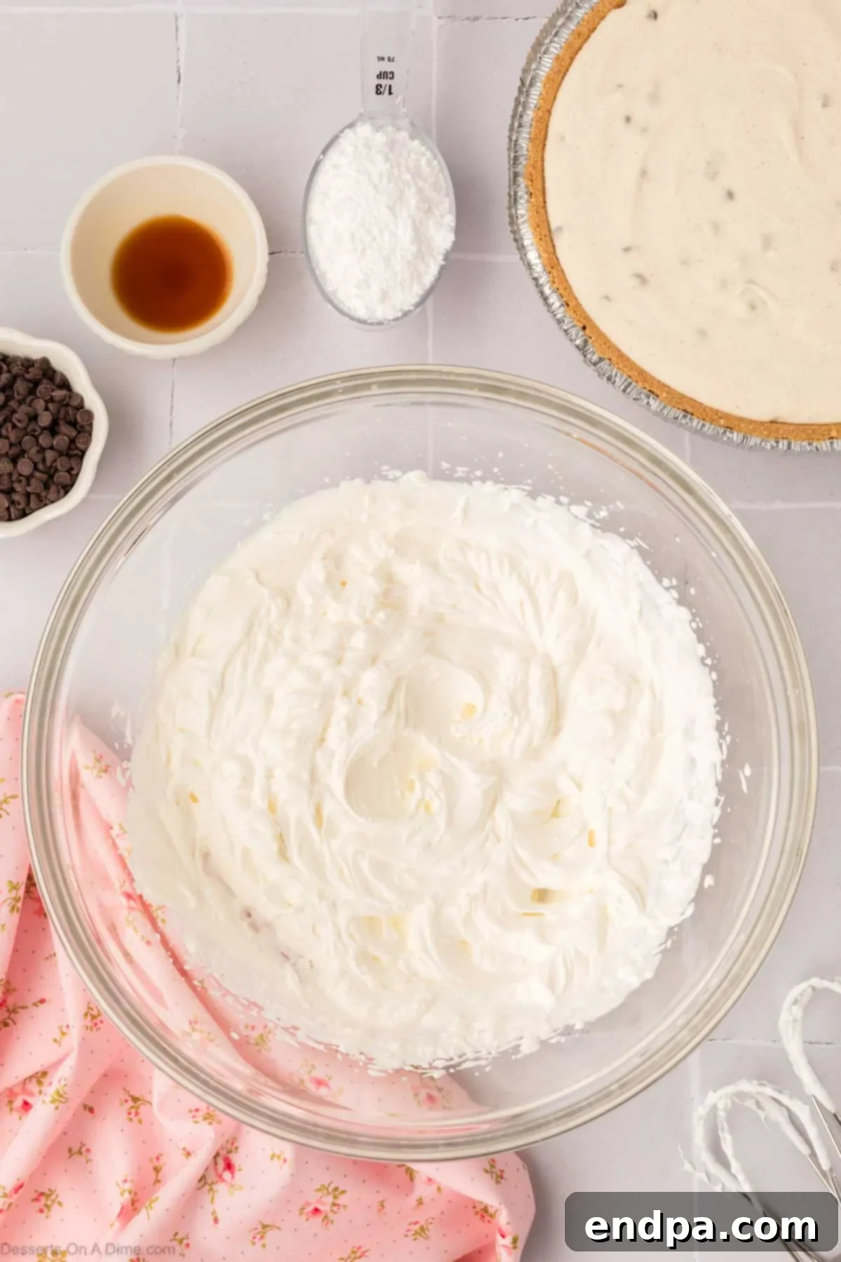 Heavy whipping cream being beaten until fluffy and forming stiff peaks, ready for the pie topping.