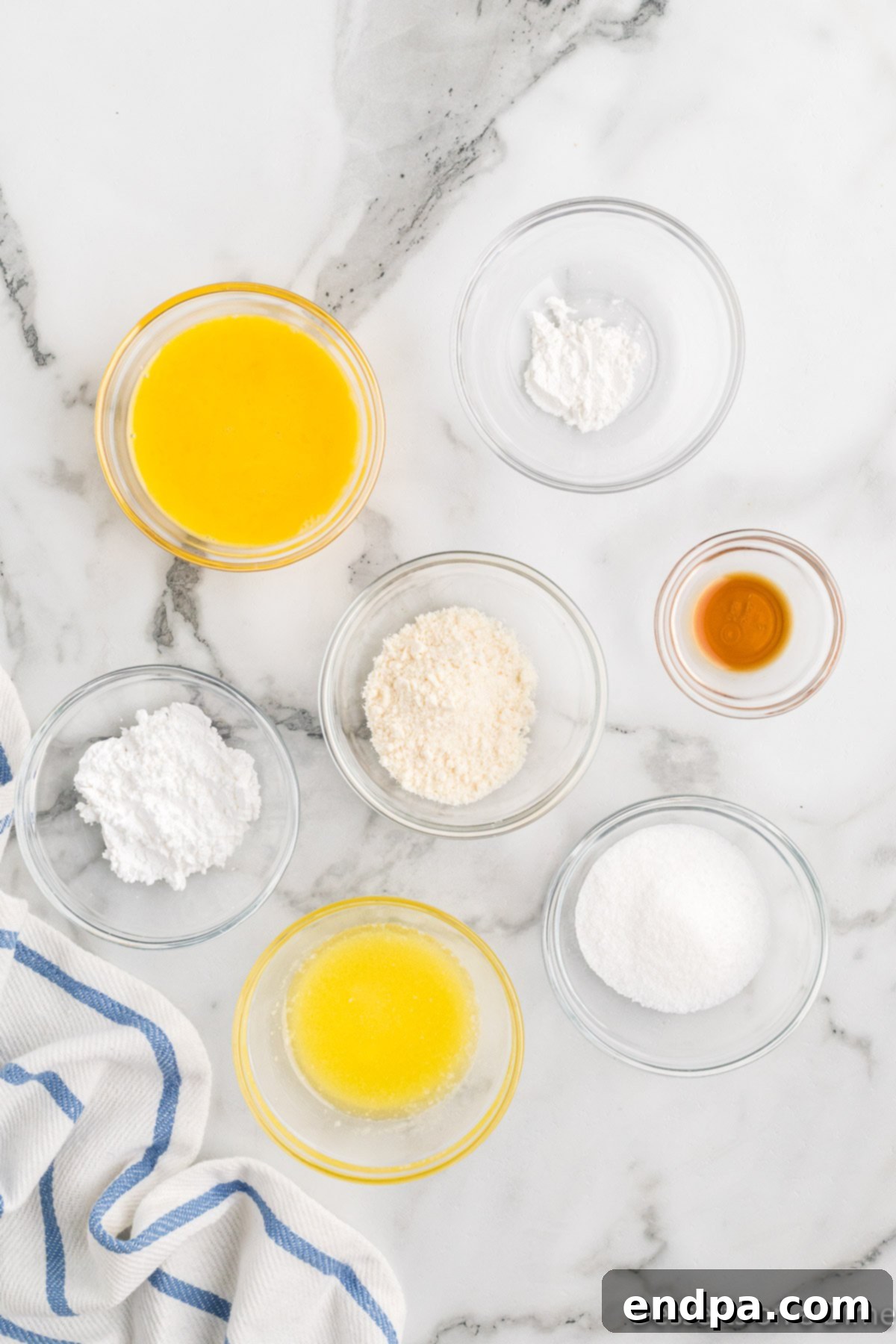 Close-up of ingredients for keto mug cake: butter, coconut flour, Swerve sweetener, baking powder, egg, and vanilla extract.