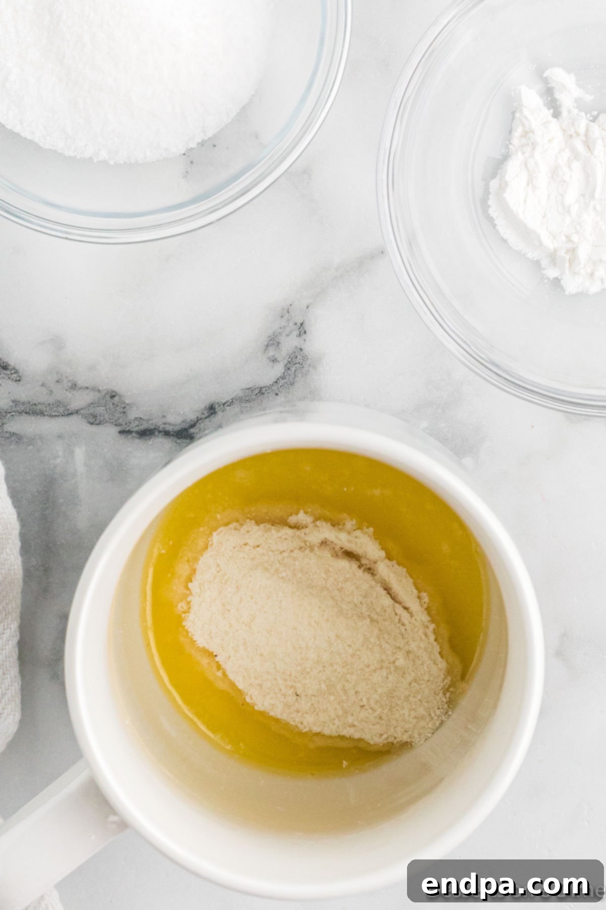 Ingredients for keto mug cake are placed into a mug, ready for mixing.