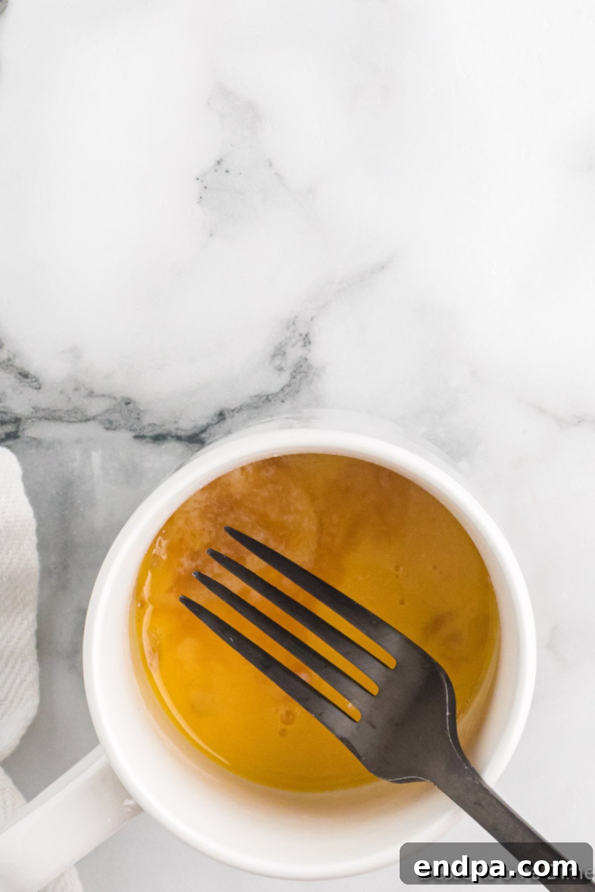 Mug cake batter thoroughly mixed in the mug with a fork, showing a smooth consistency.