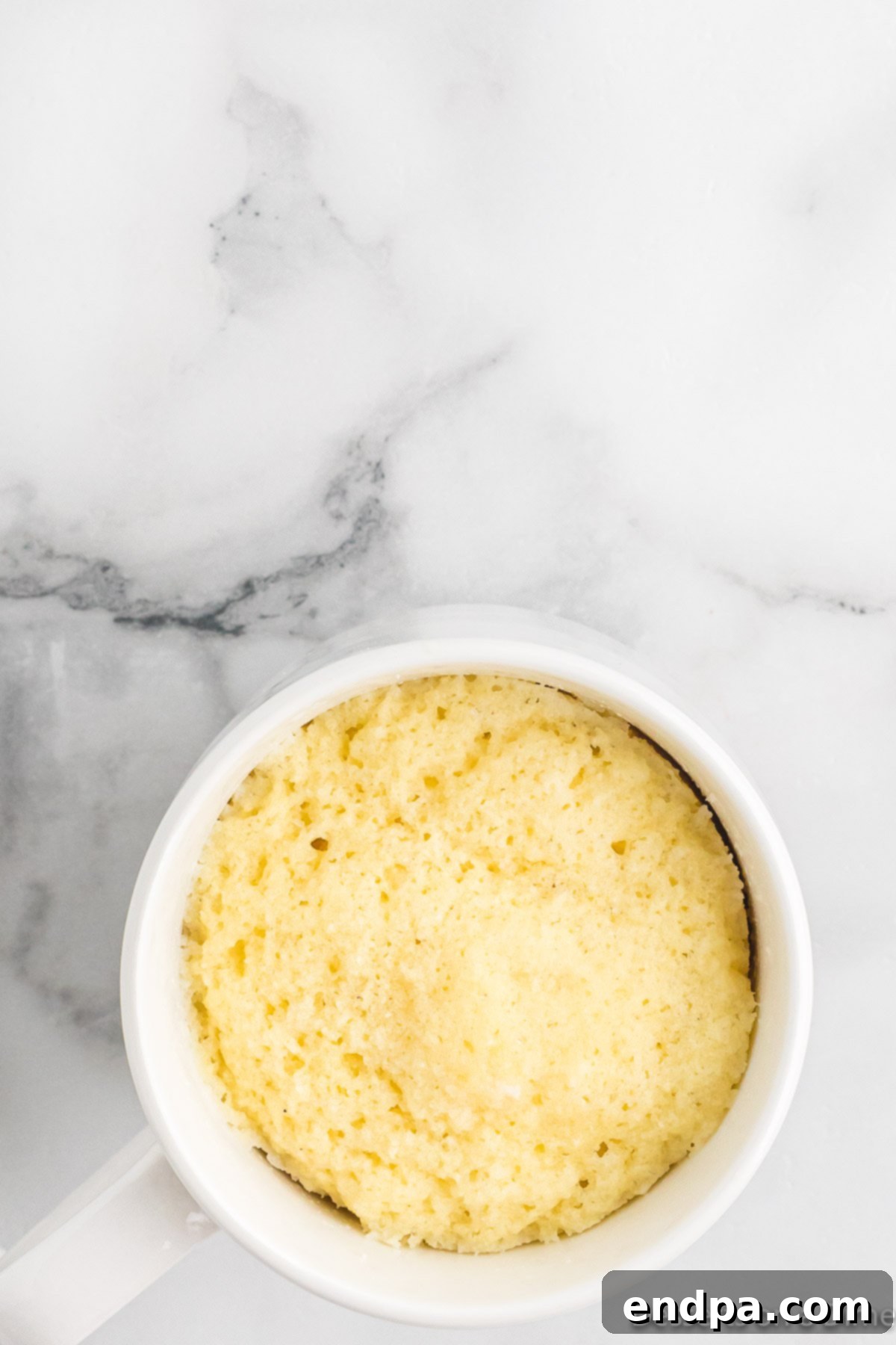 The cooked keto mug cake inside the mug, appearing risen and golden.