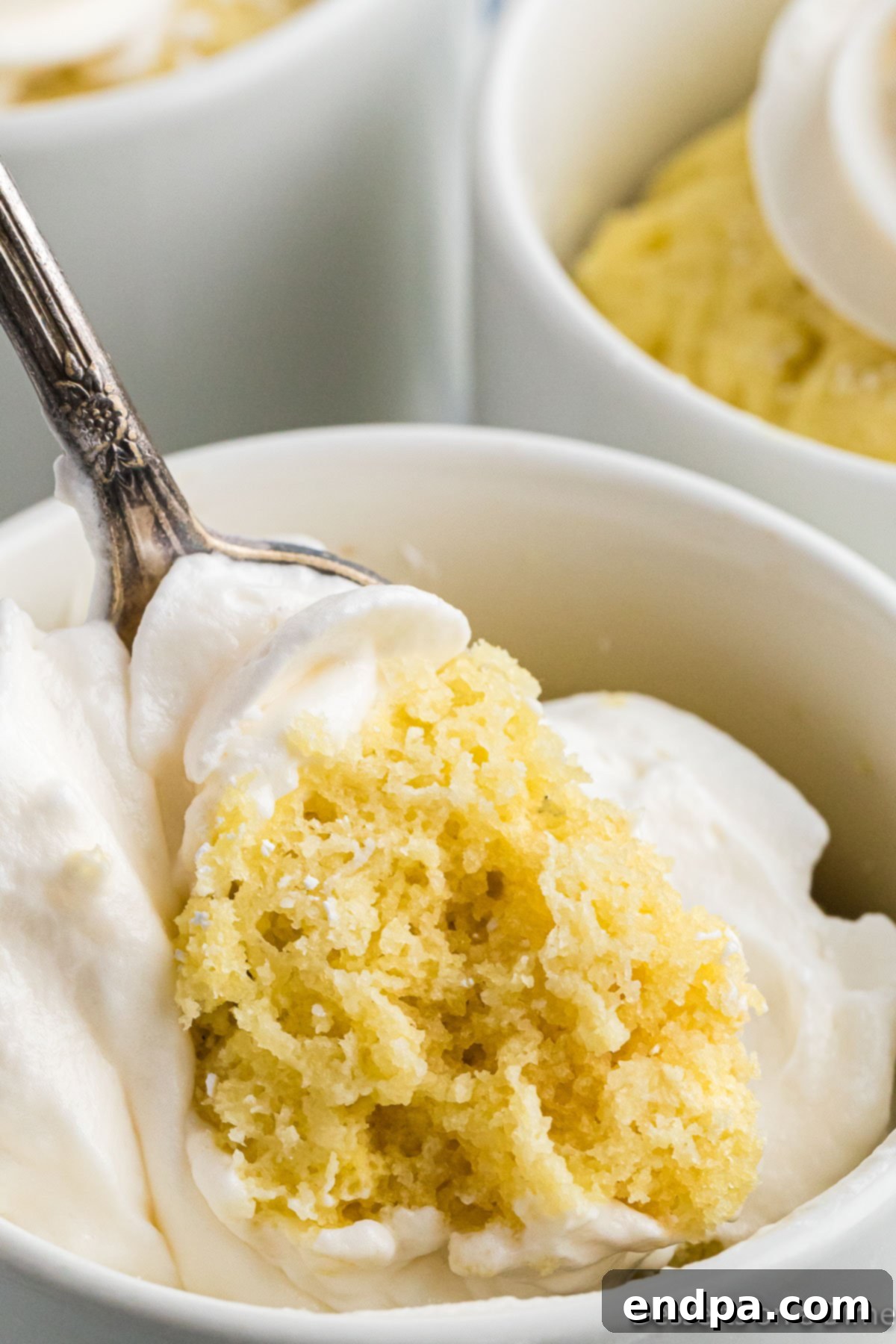 Finished mug cake topped with whipped cream and a sprinkle of Swerve confectioner's sugar.